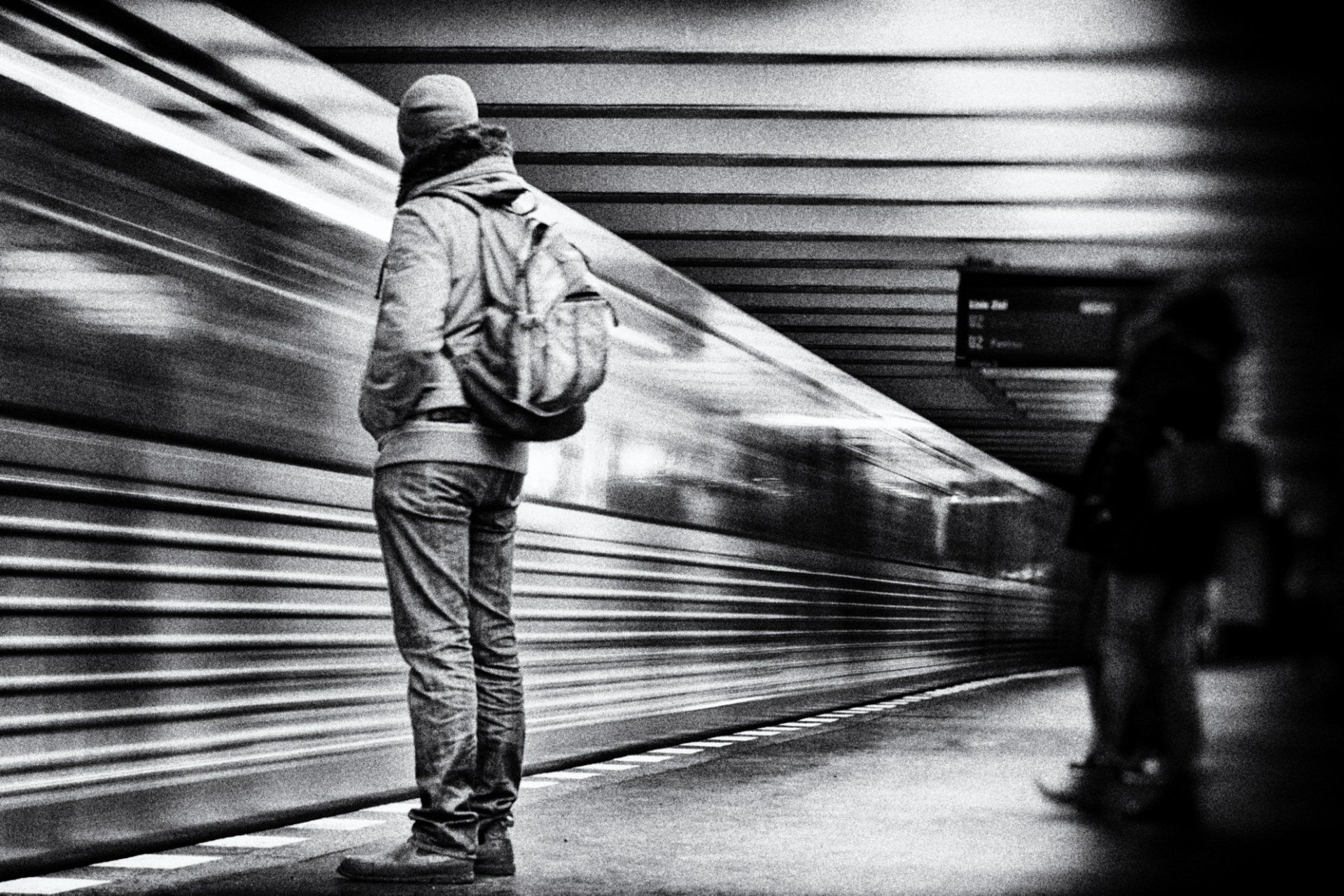 Ein Mann steht vor einer abfahrenden U Bahn in Berlin Prenzlauer Berg. Street photography aus Berlin