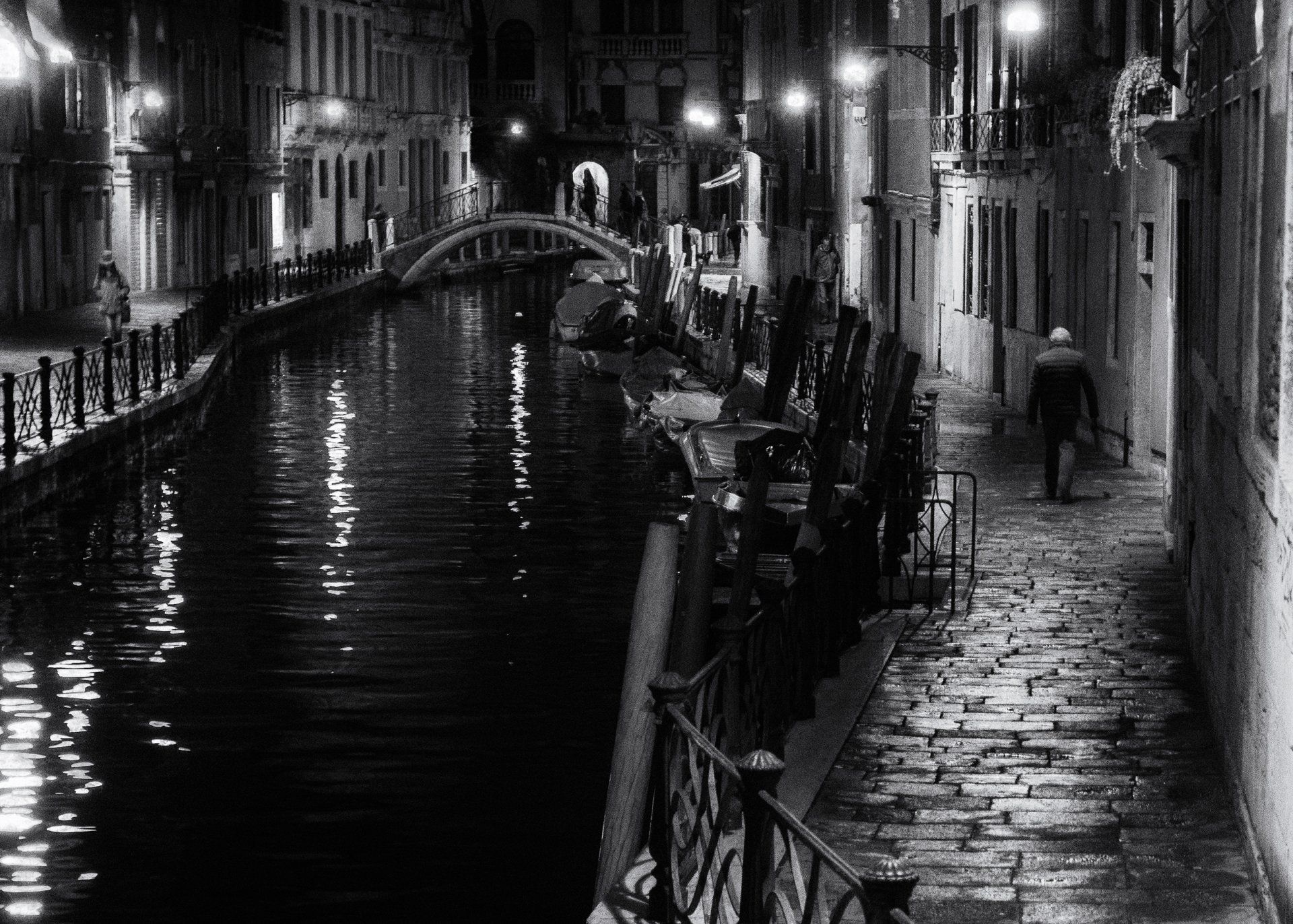Street Photography Venedig - Menschen gehen allein an einem beleuchteten Kanal in der altstadt von Venedig