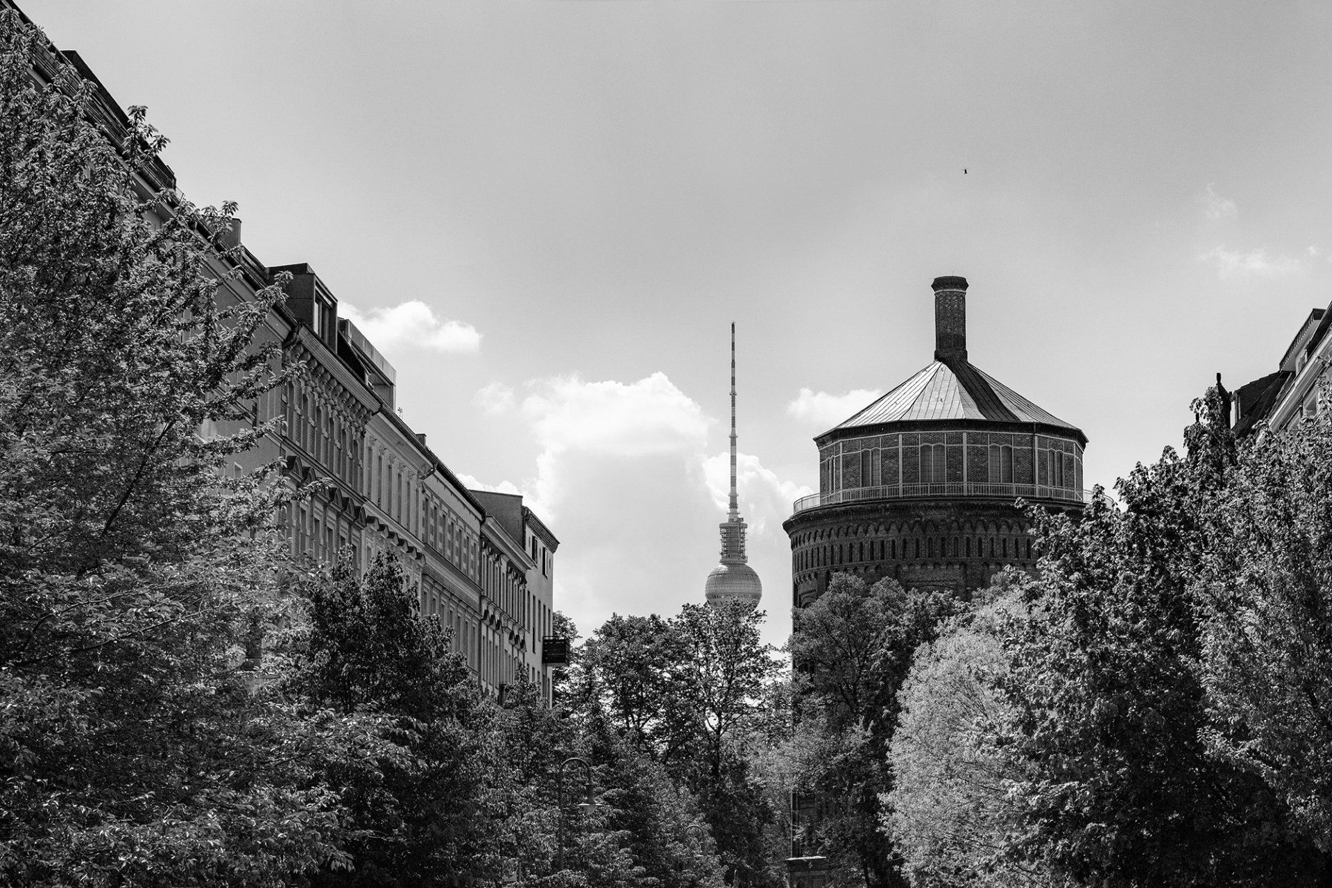 Der Wasserturm , Wahrzeichen von Berlin Prenzlauer Berg an einem sonnigen Tag. Im Hintergrund der Berliner Fernsehturm. Stadtfotografie aus Berlin in schwarz und weiß.