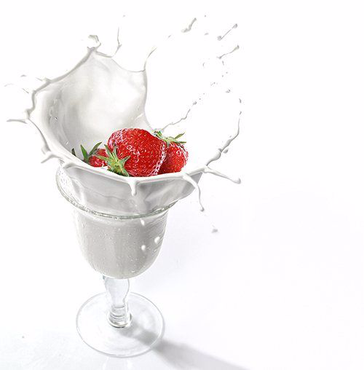 Glas, spritzende Milch, Milchtropfen und Erdbeeren, Dessert