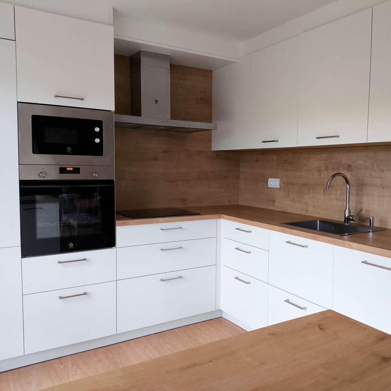 Cocina con encimera laminada de madera combinada con trasera en pared, diseñada por Sallende Cocinas