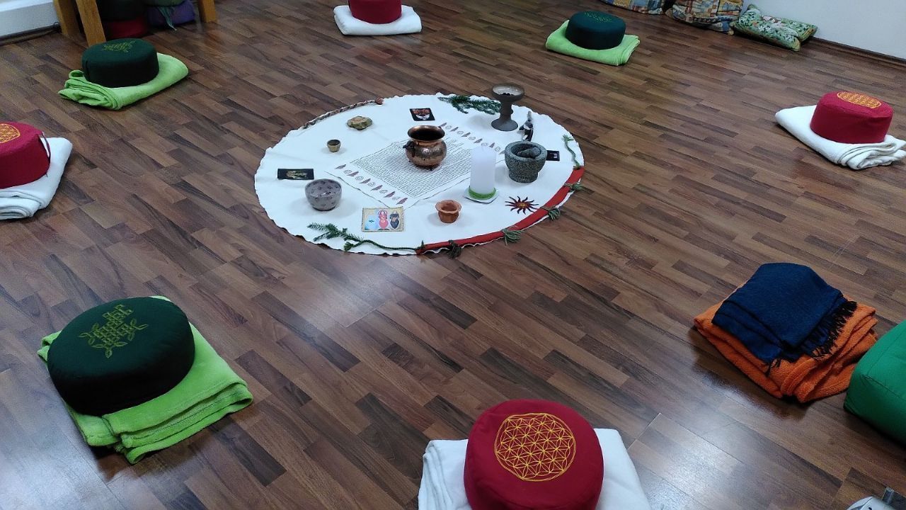 Kreis mit Sitzkissen und Decken und einer dekorierten runden Mitte