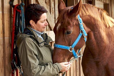 Bild: Anne Dobberkau mit Pferd Anne Dobberkau mit Pferd vor einem Reitstall