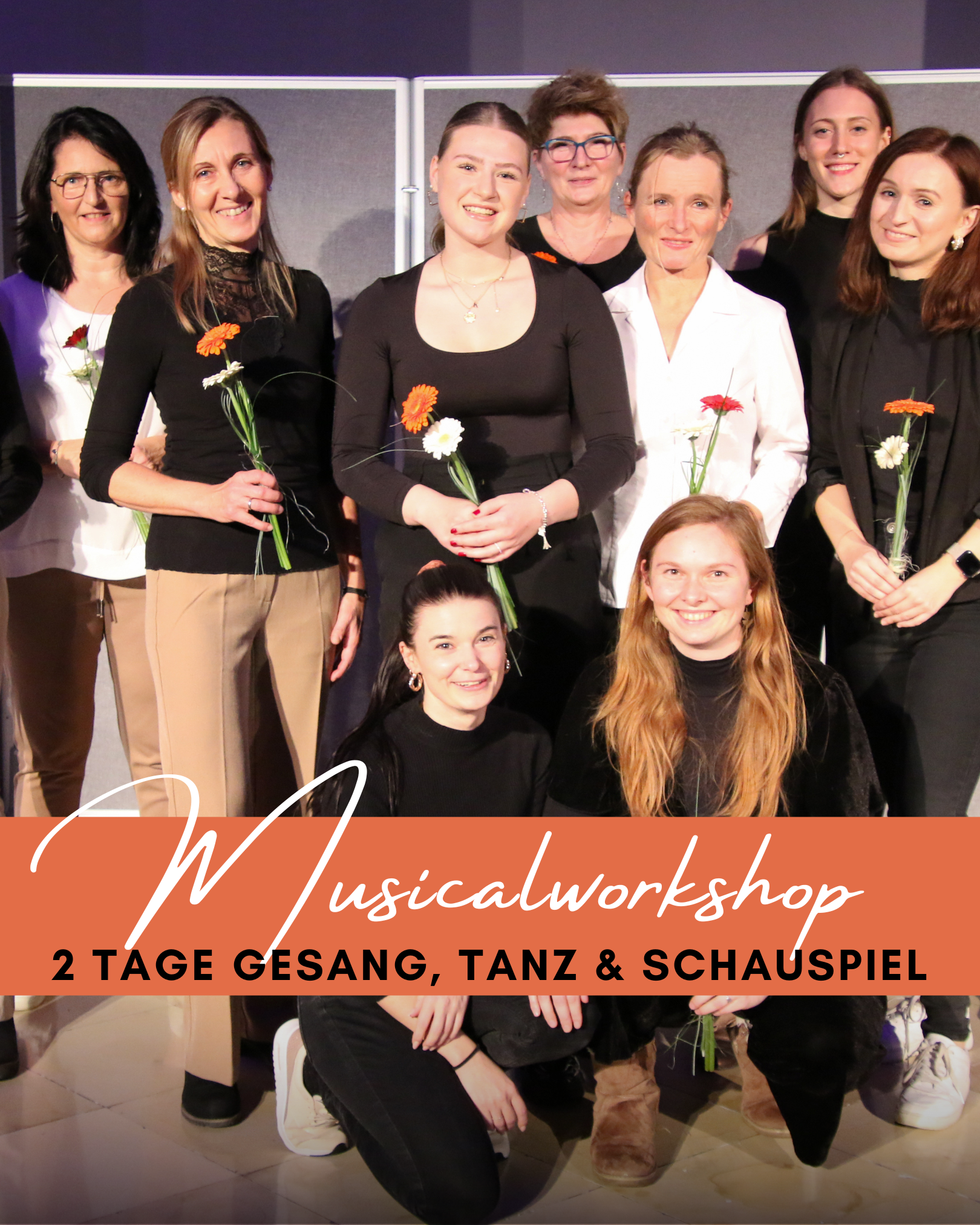 eine Gruppe Frauen mit Blumen in der Hand alle lachen - zwei Leiterinnen ohne Blume knien am Boden und lachen