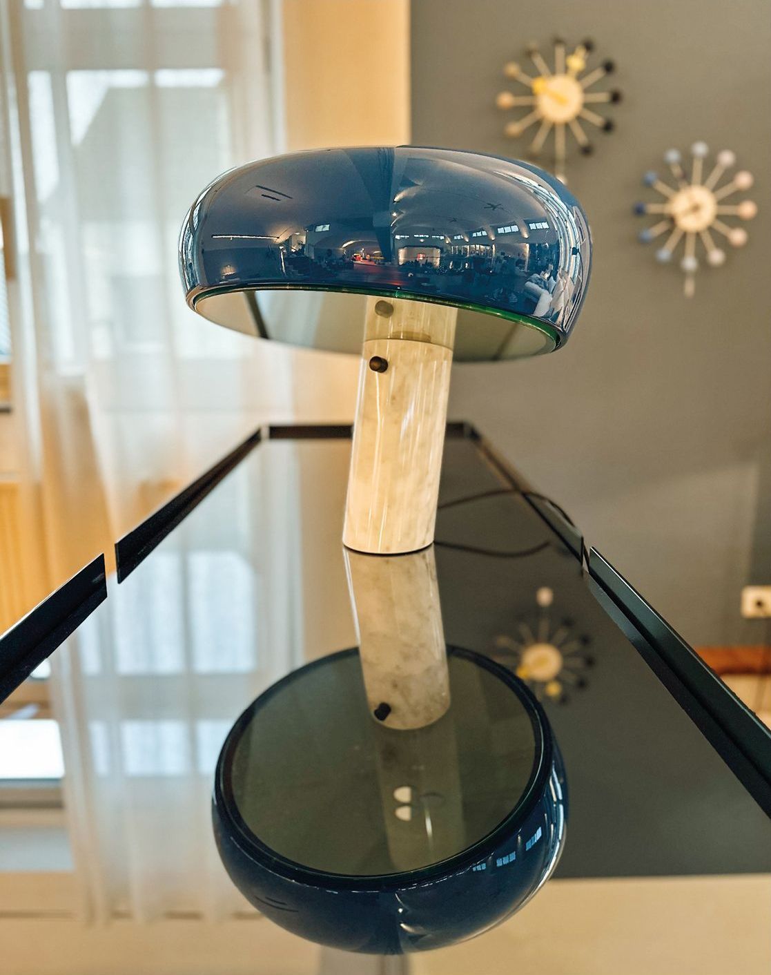 Blaue Tischleuchte auf einer gläsernen Vitrine