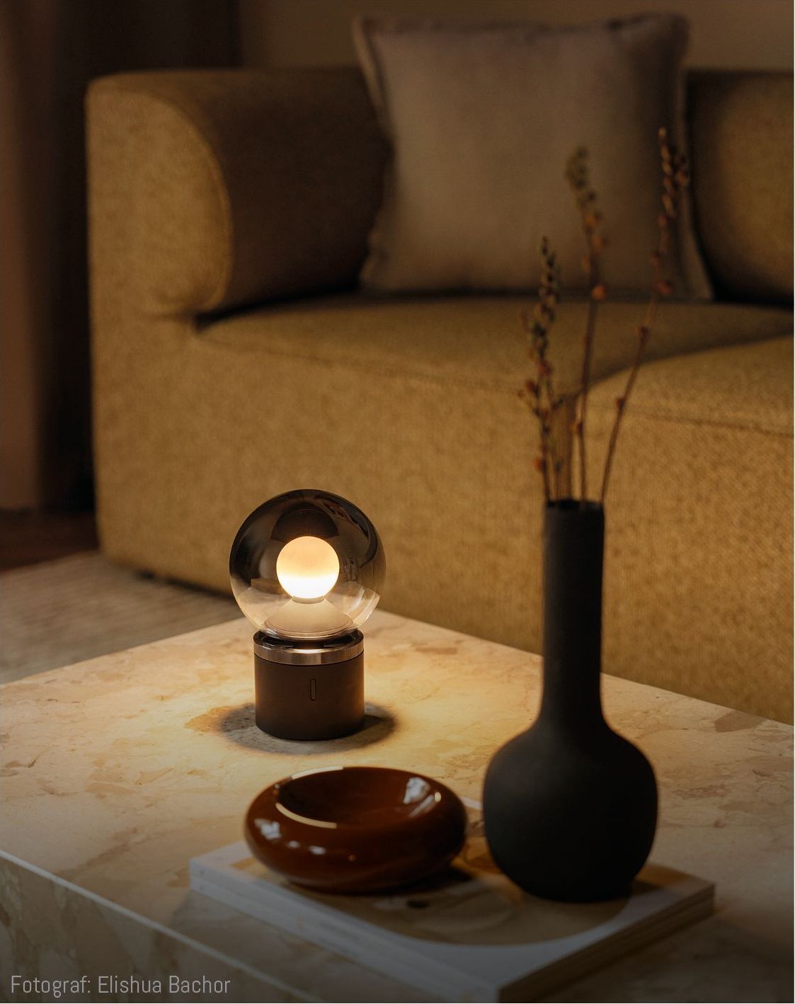 Tischleuchte mit kugelförmigem Leuchtkörper auf einem Tisch