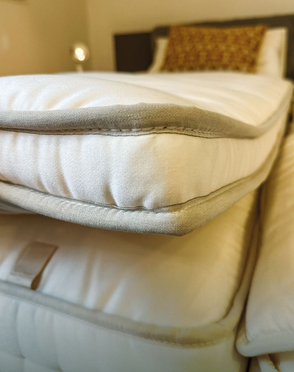 Ausschnitt eines Bettes mit Rahmen, Matratze und Topper