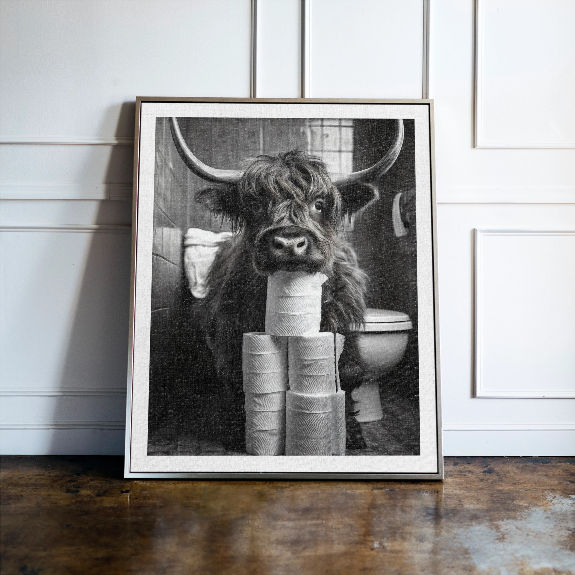black and white image of a highland cow in the bathroom resting it's head on toilet rolls
