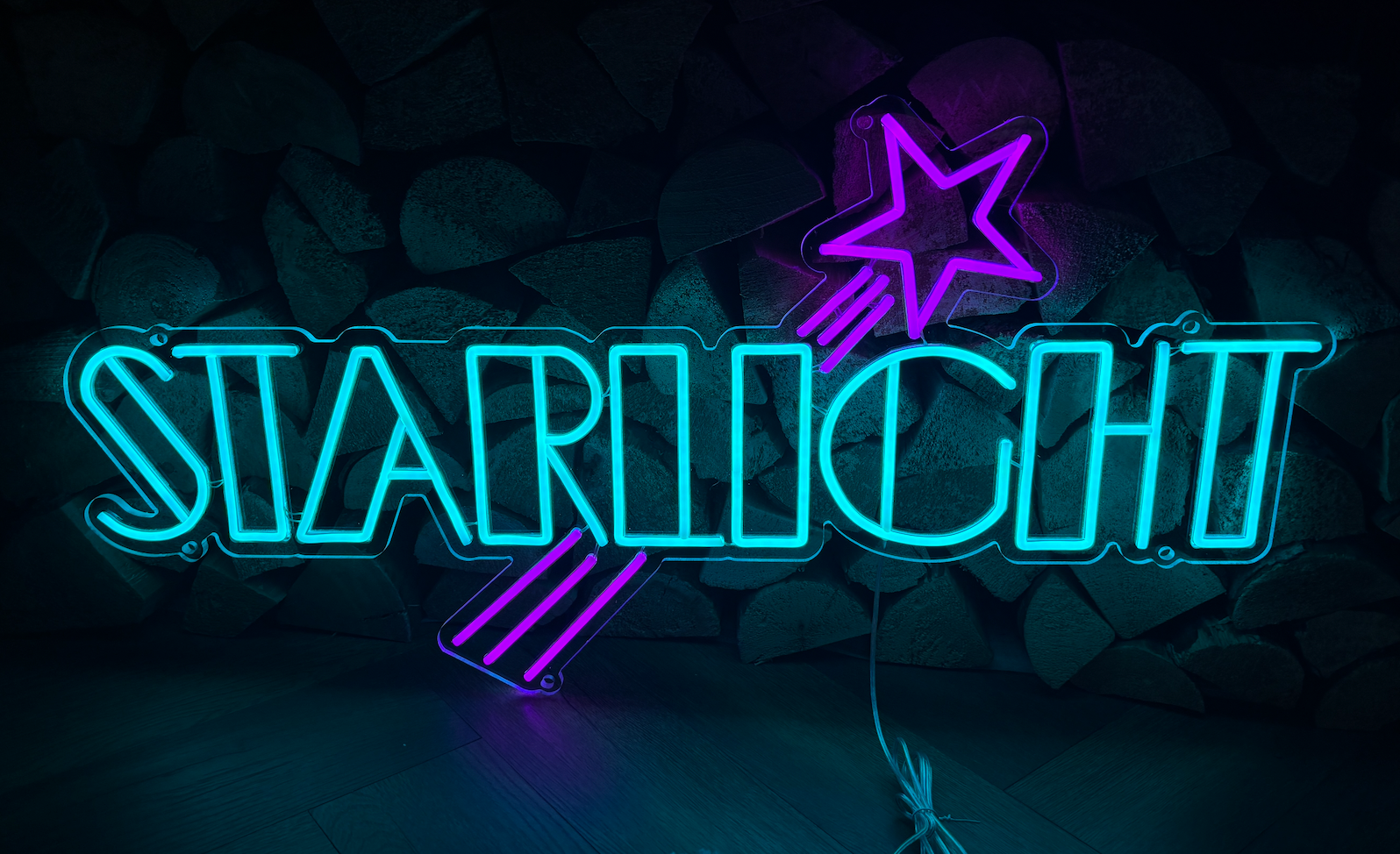 a light blue led neon sign with the word starlight and a purple star going through the middle