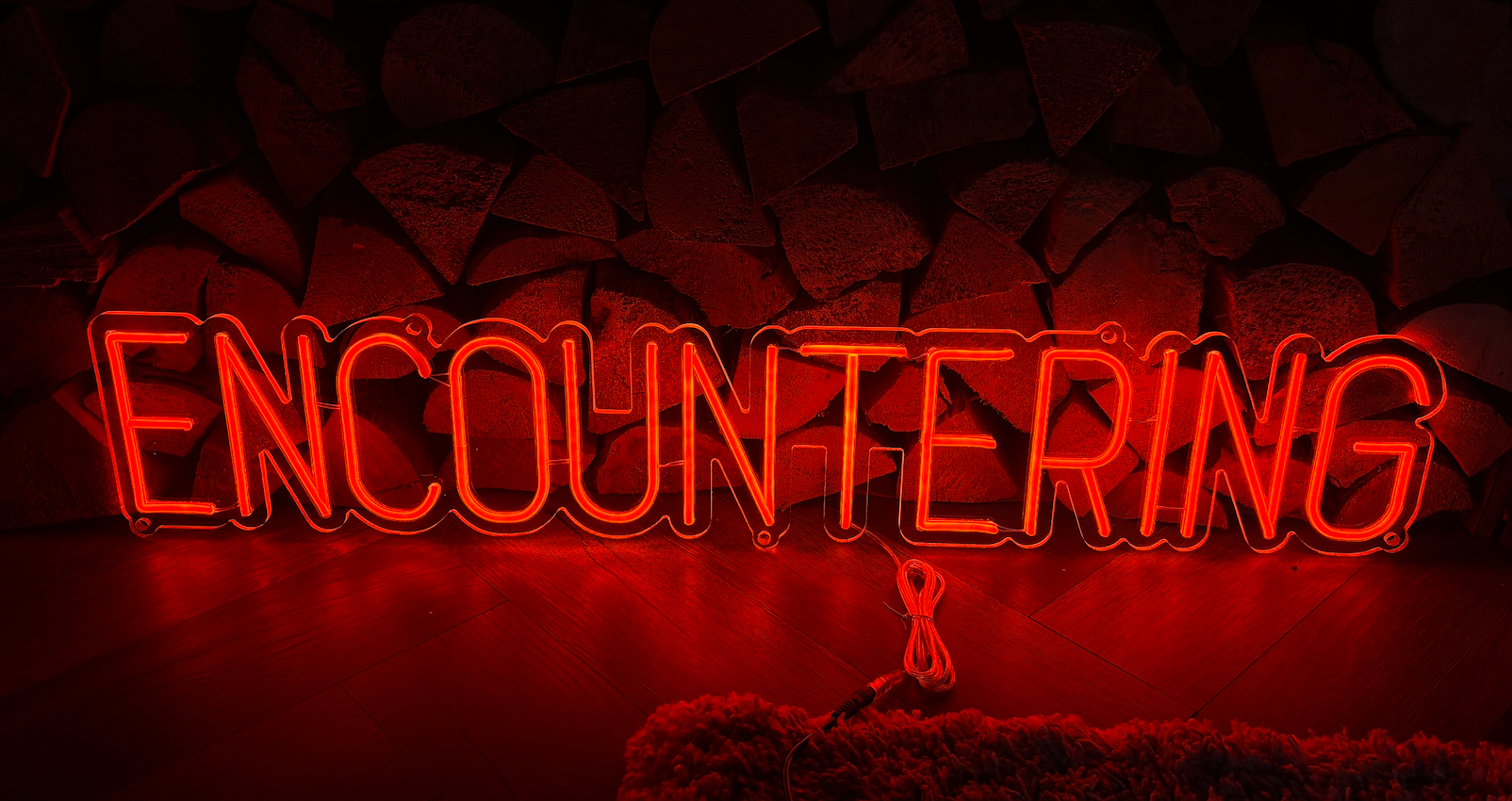 an orange led neon sign in the word encountering