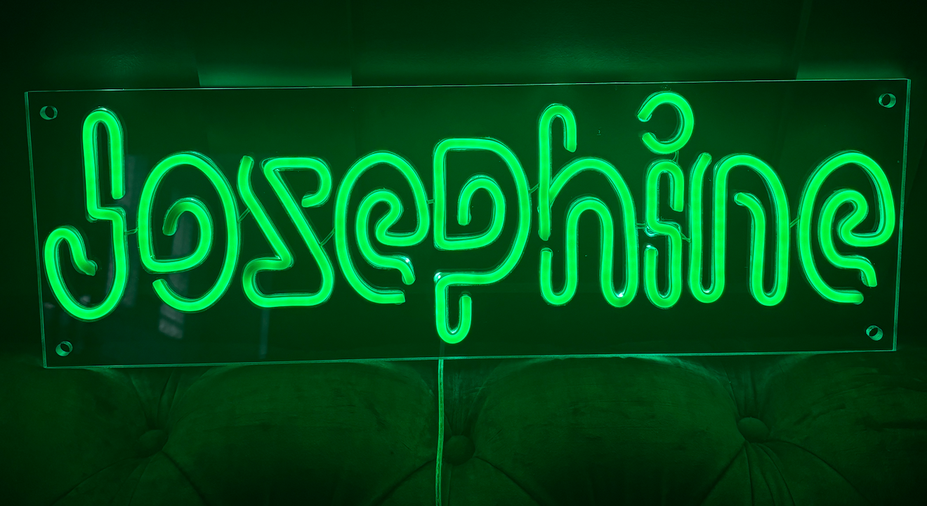 an led neon sign in green with a customers name