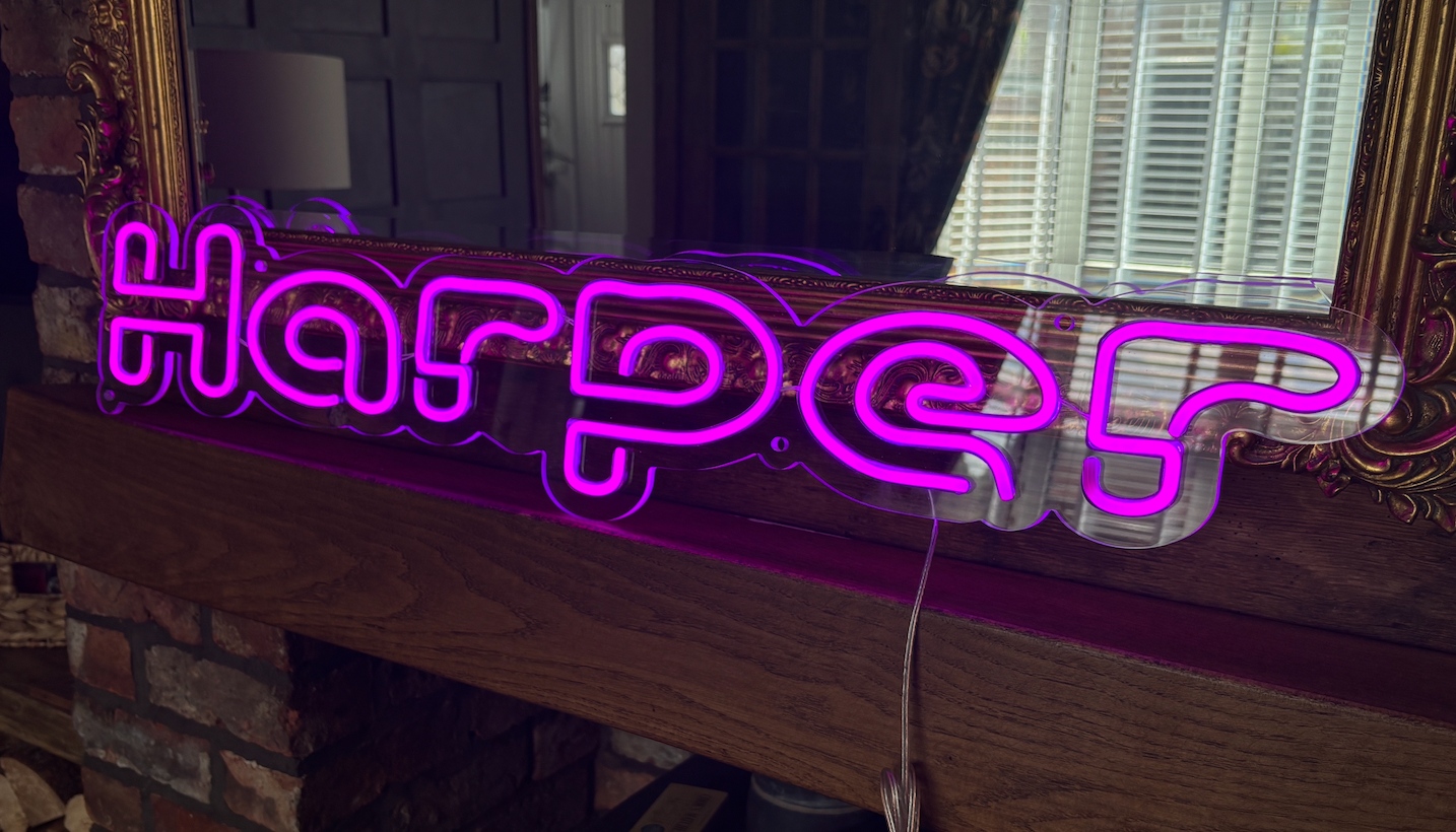 a purple led neon sign in the shape of the word 'harper'