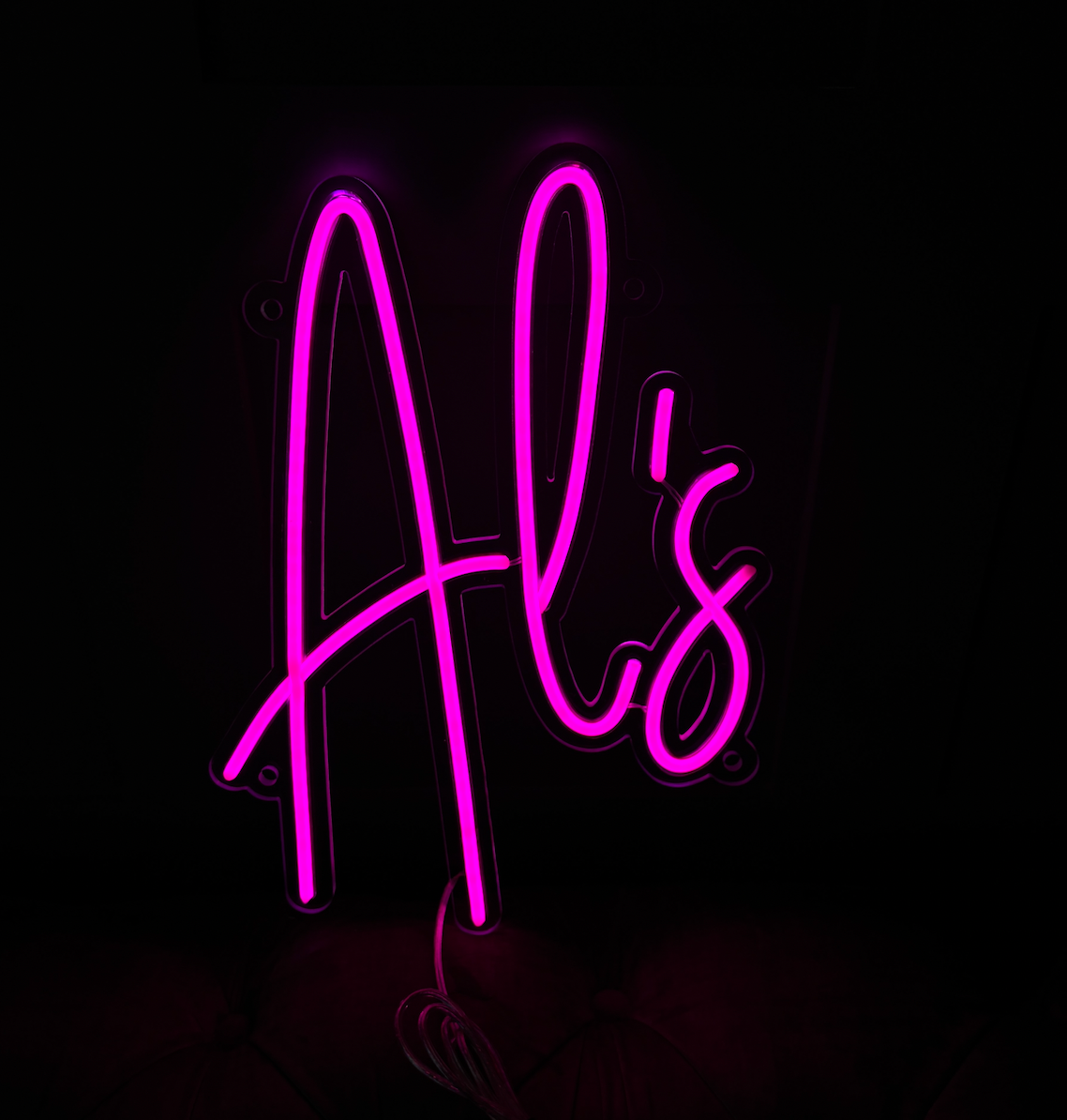 a hot pink led neon sign saying 'Al's