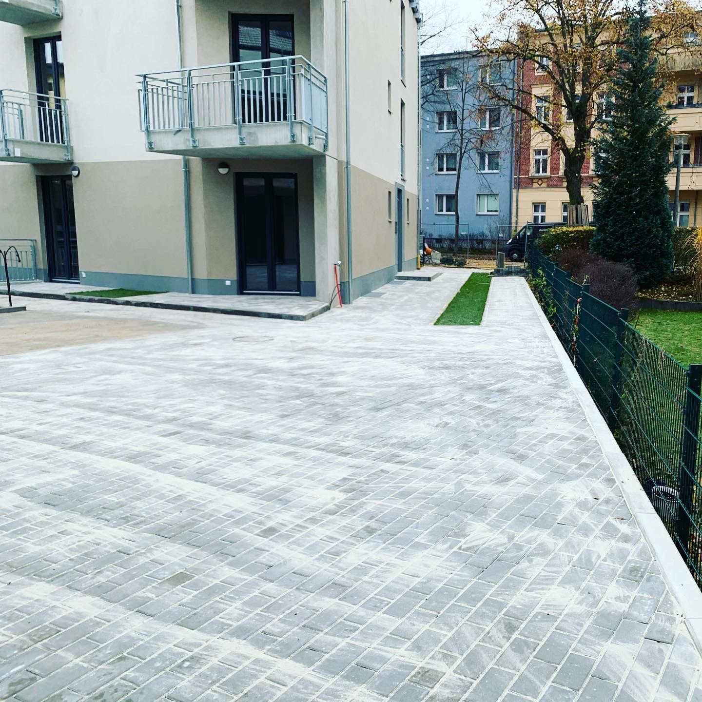 Verbundpflaster Frisch verlegte Pflastersteine in einem modernen Wohnkomplex – hochwertige Pflasterarbeiten für Einfahrt, Hof und Gehwege.