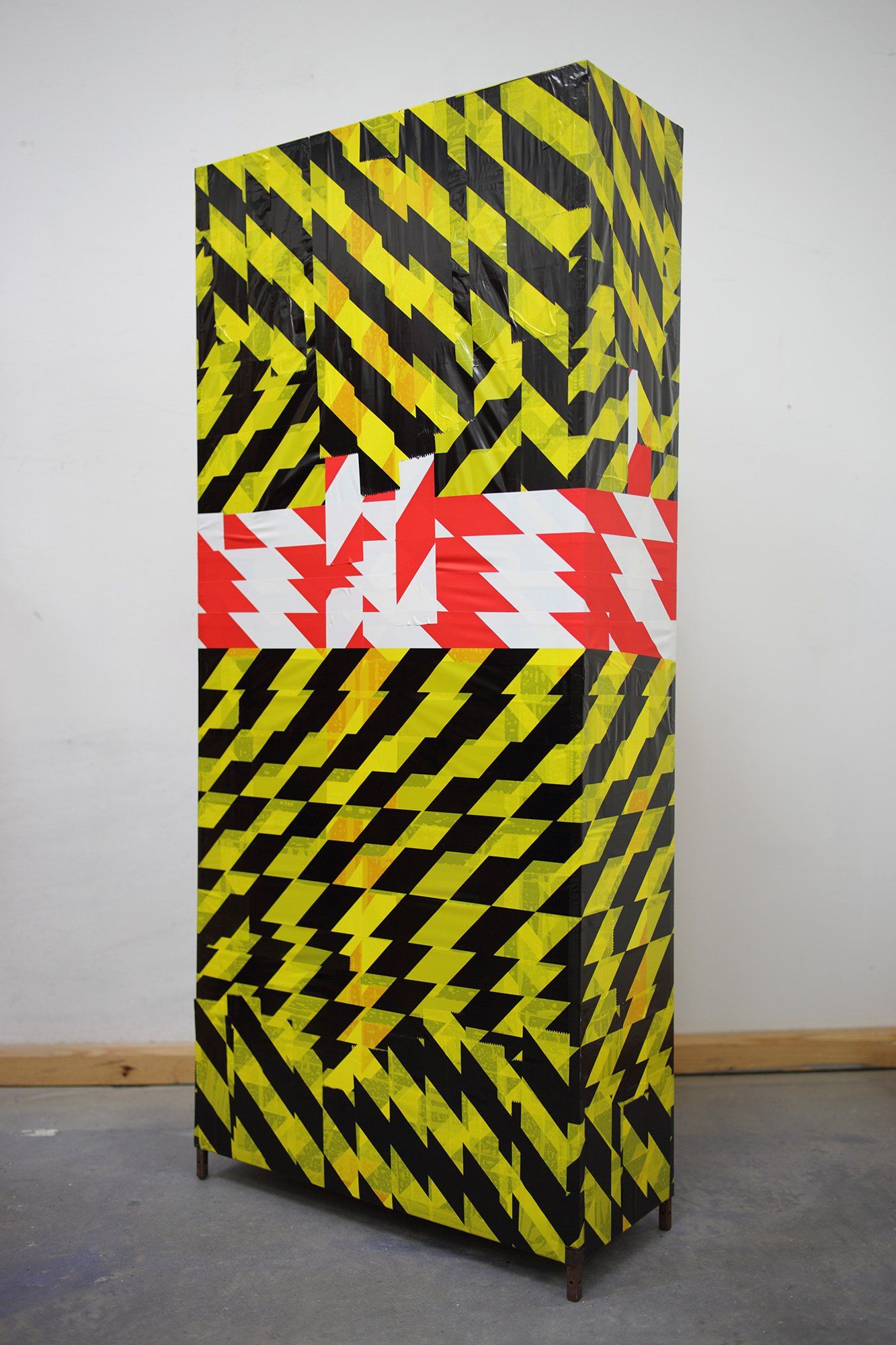 „Barrier Tape Tower No. 1“ by Sebastian Bieniek (B1EN1EK), the inventor of „Barrier Tape Art“. Created in may 2020. Size: 114 cm. x 50 cm. x 20 cm.