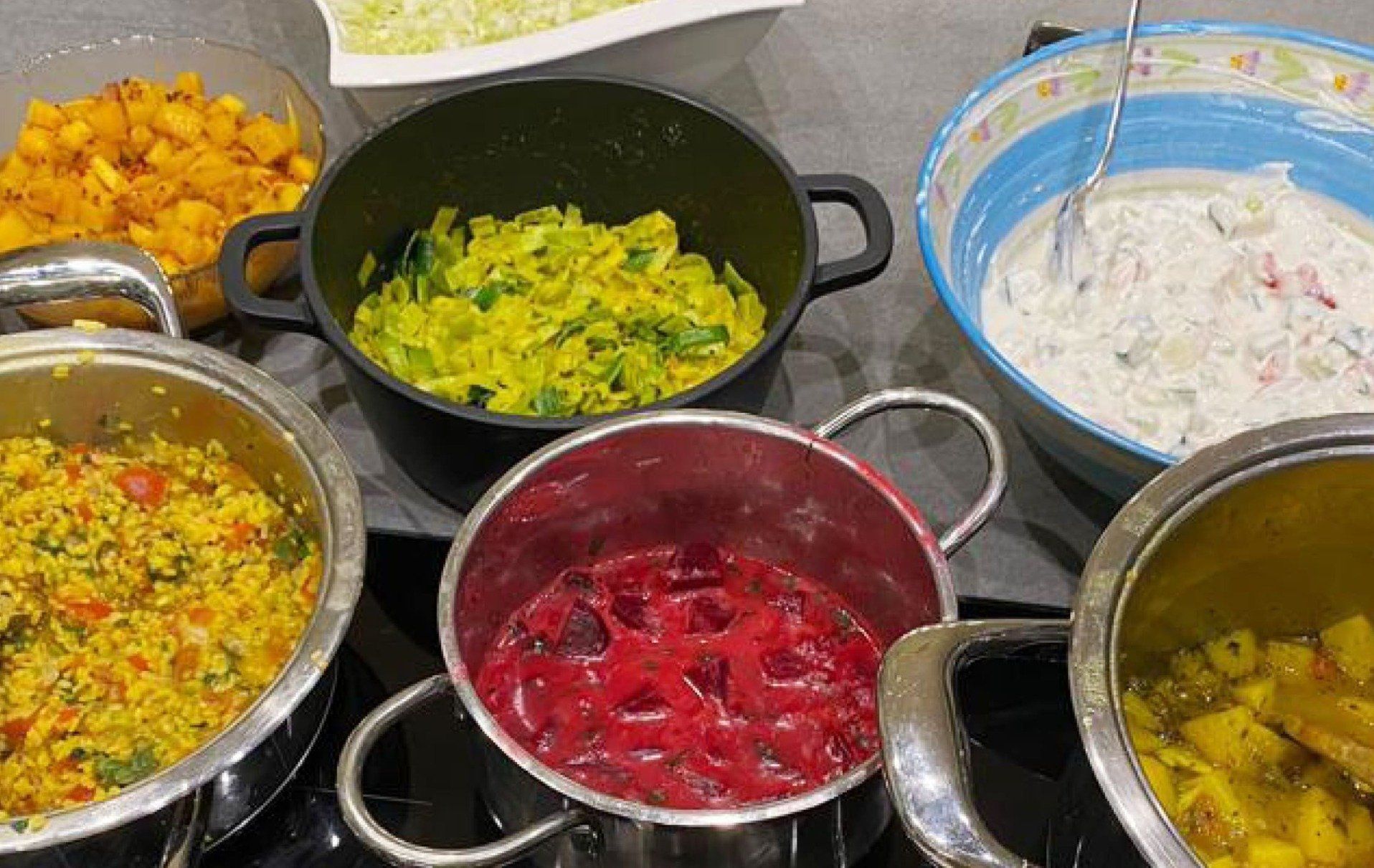 Kochtöpfe mit verschiedenen bunten ayurvedischen Gerichten