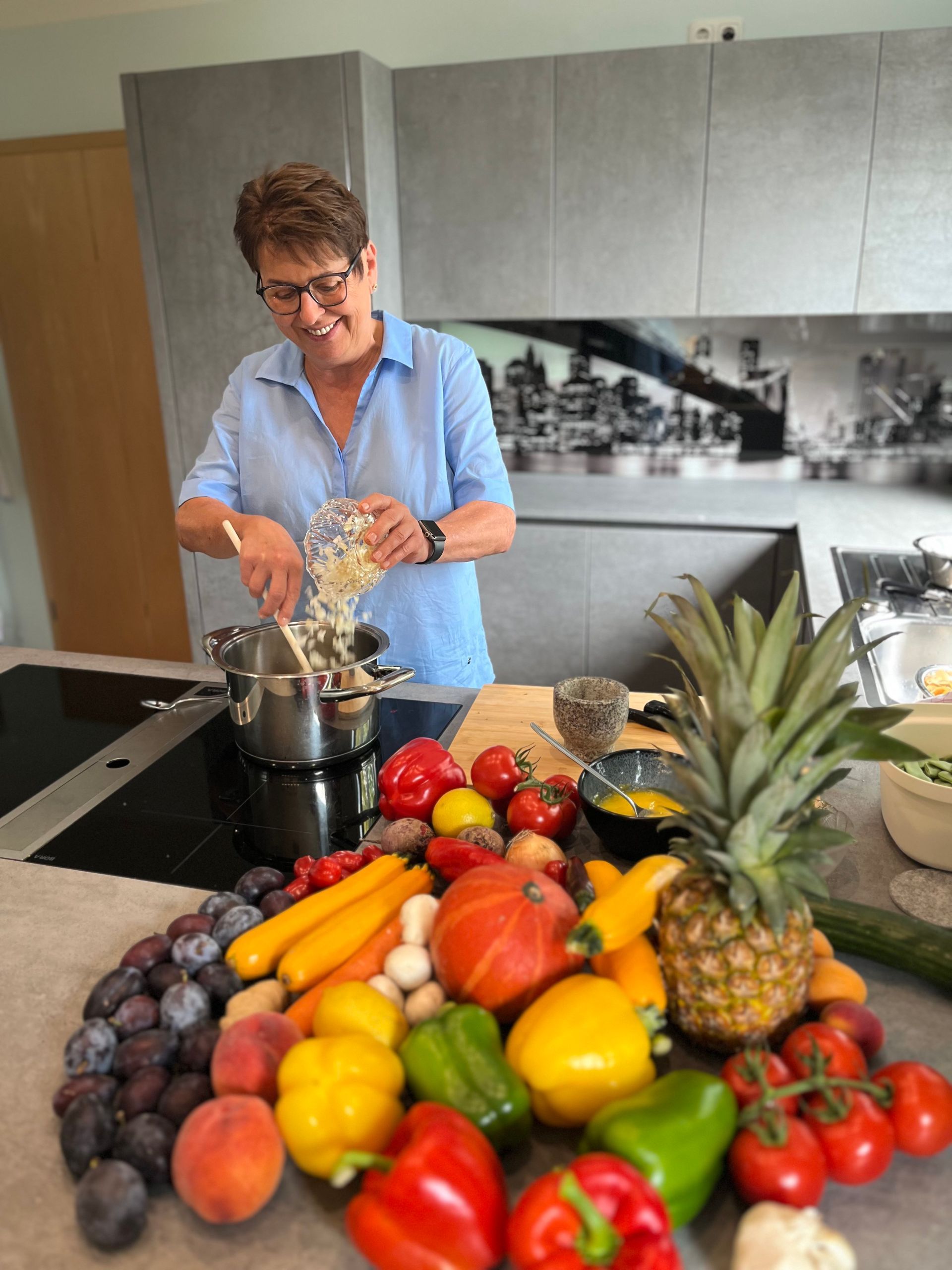 Elke Landisch, Ayurvedaköchin, Köchin und Ernährungsspezialistin aus Landshut, gibt frisch geschnittene Zwiebeln in einen Kochtopf, um ein ayurvedisches Gericht während eines Kochkurses zuzubereiten.