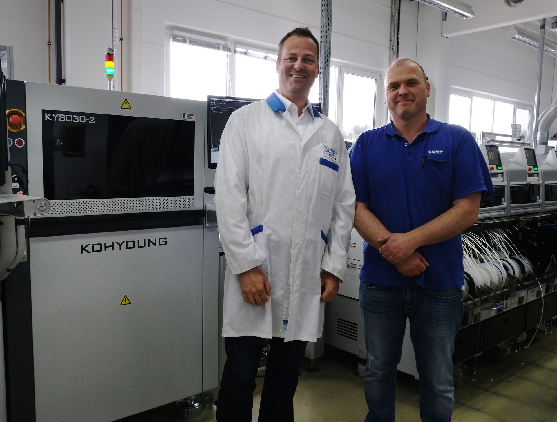 Andreas Keller und Mathias Winzerling vor dem Koh Young 3D SPI bei Christ Elektronik
