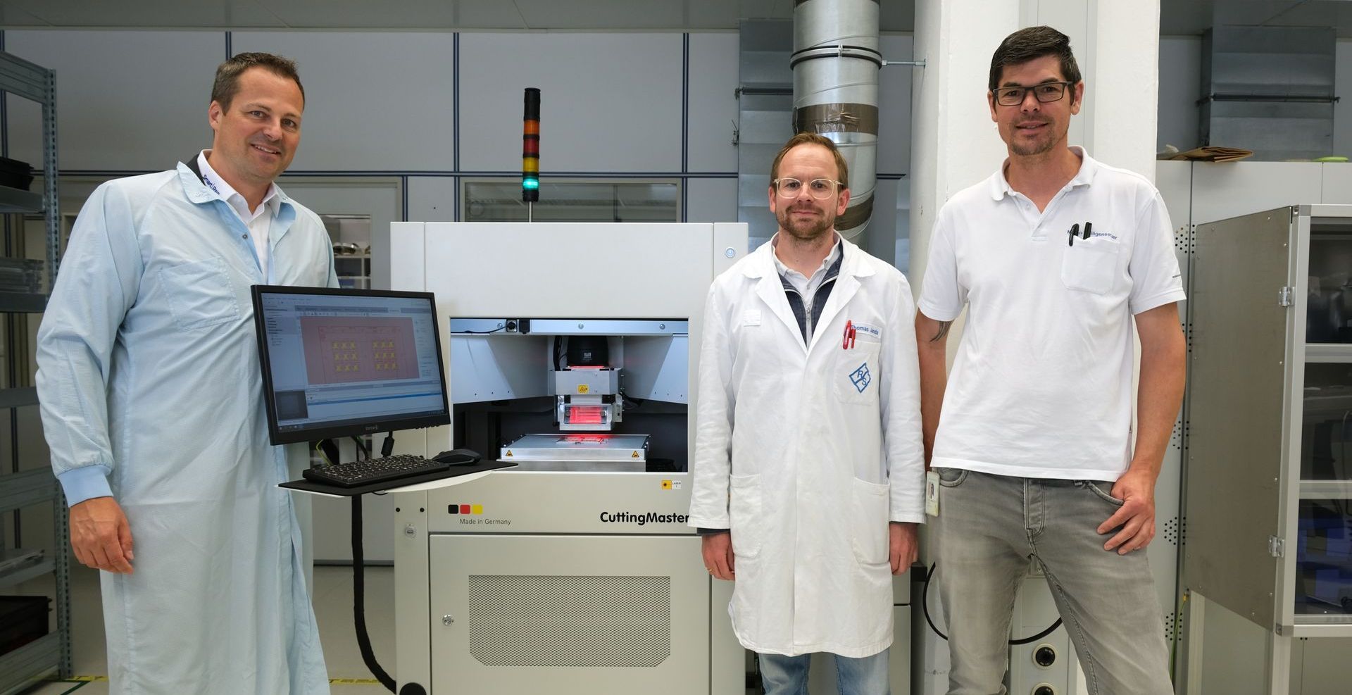 Andreas Keller von SmartRep mit Thomas Janda und Marco Heiligensetzer vor dem CuttingMaster bei Rohde&Schwarz