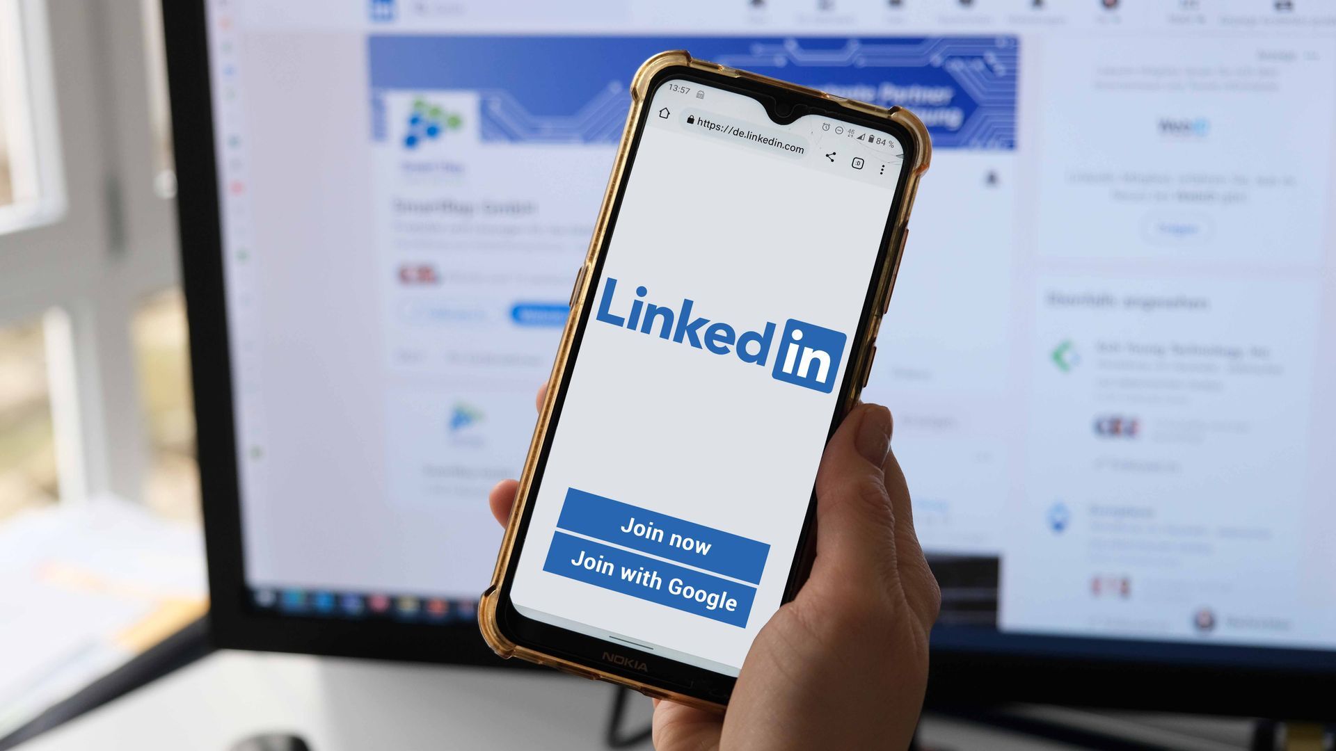 Handy mit LinkedIn Login vor PC auf dem das SmartRep LinkedIn-Profil zu sehen ist