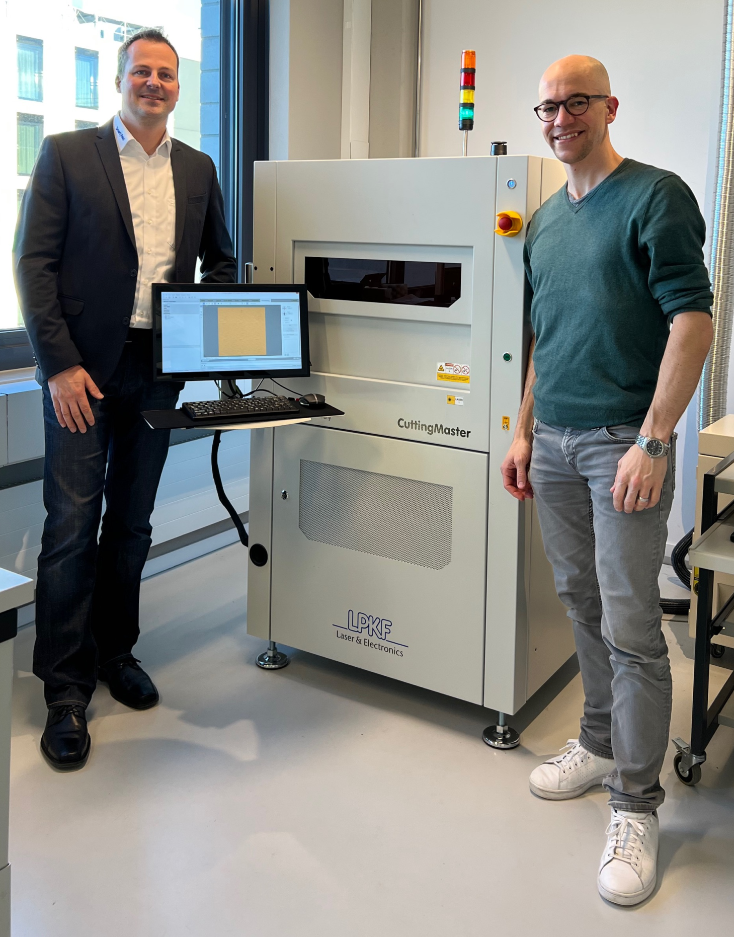 Etienne Schwyter von greenTEG und Andreas Keller vor dem CuttingMaster von LPKF