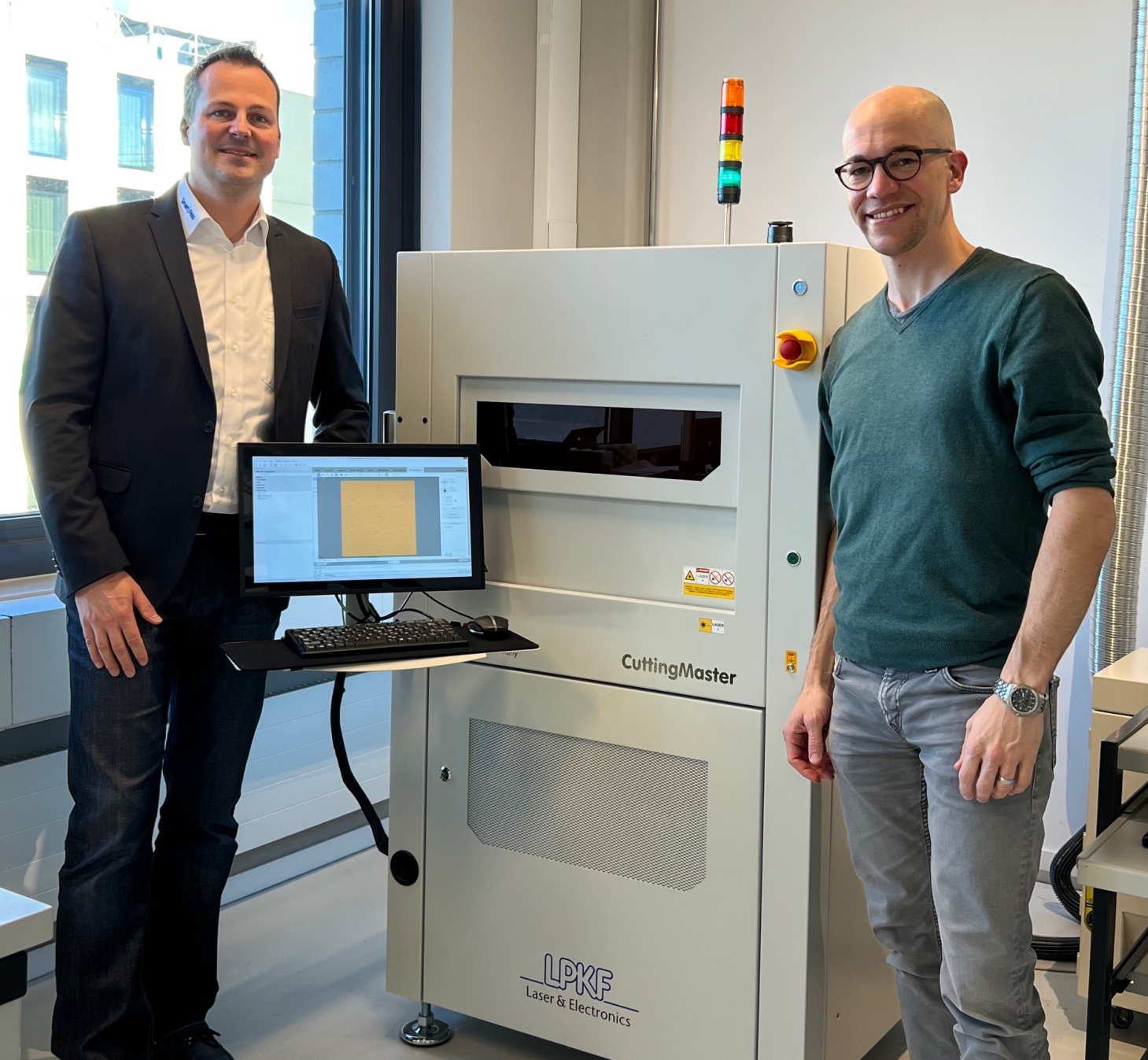 Etienne Schwyter von greenTEG und Andreas Keller vor dem CuttingMaster von LPKF