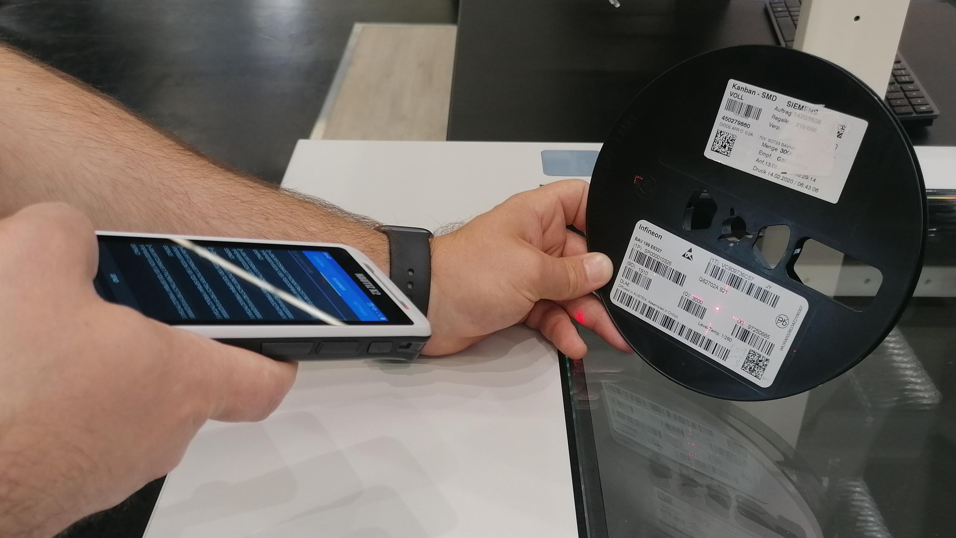 Eine Bauteilrolle wird mit dem mobilen Scanner von MODI vereinnahmt