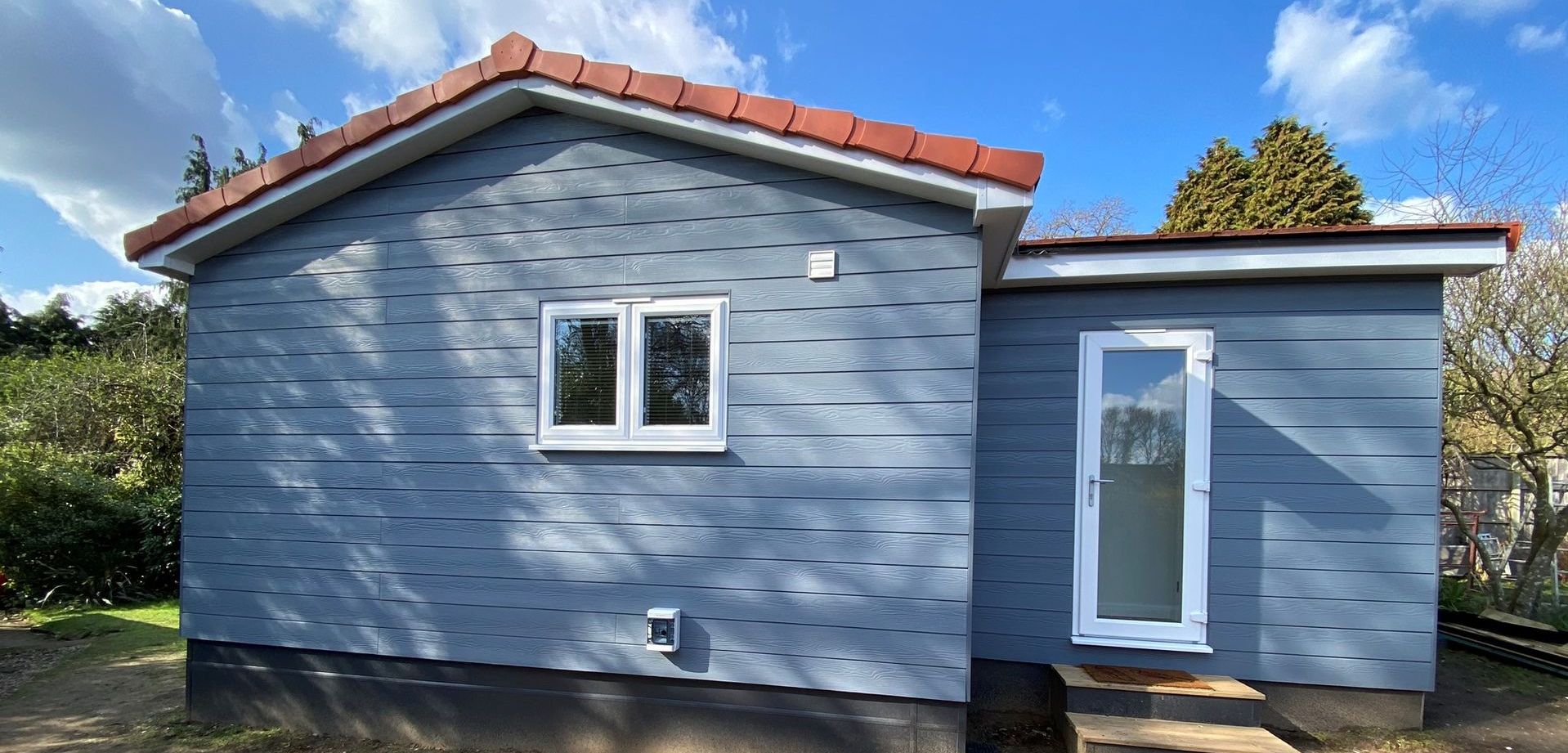 Modern granny annexe with open-plan living and large windows built by TRJ Construction Ltd