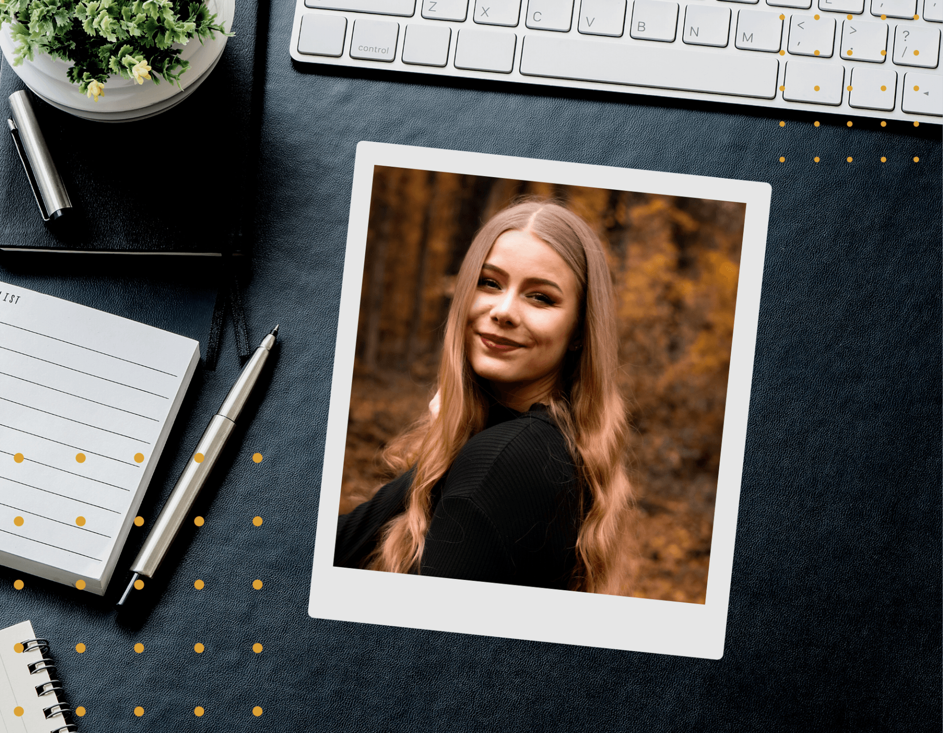 Foto eines dunklen Schreibtisches auf dem eine weiße Tastatur, eine Pflanze und ein Notizblock liegen in der Mitte ist eine Polaroid von Sira, sie*er hat lange blonde gelockte Haare, trägt dunklen Lippenschtift und schaut lächelnd über eine Schulter. Unten Links und oben rechts ist eine Ansammlung von gelben Punkten.