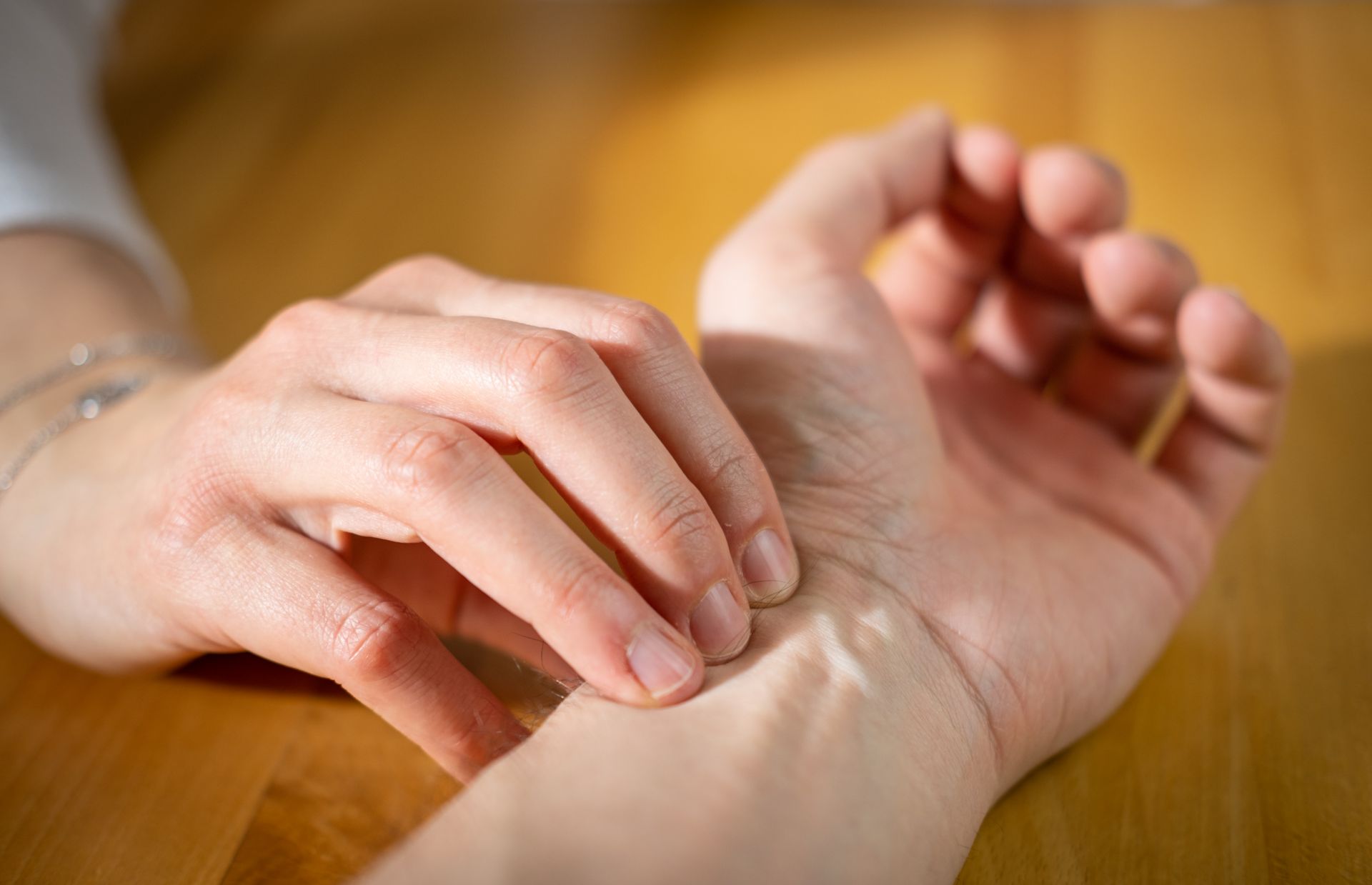 Zwei Hände bei Pulsmessung