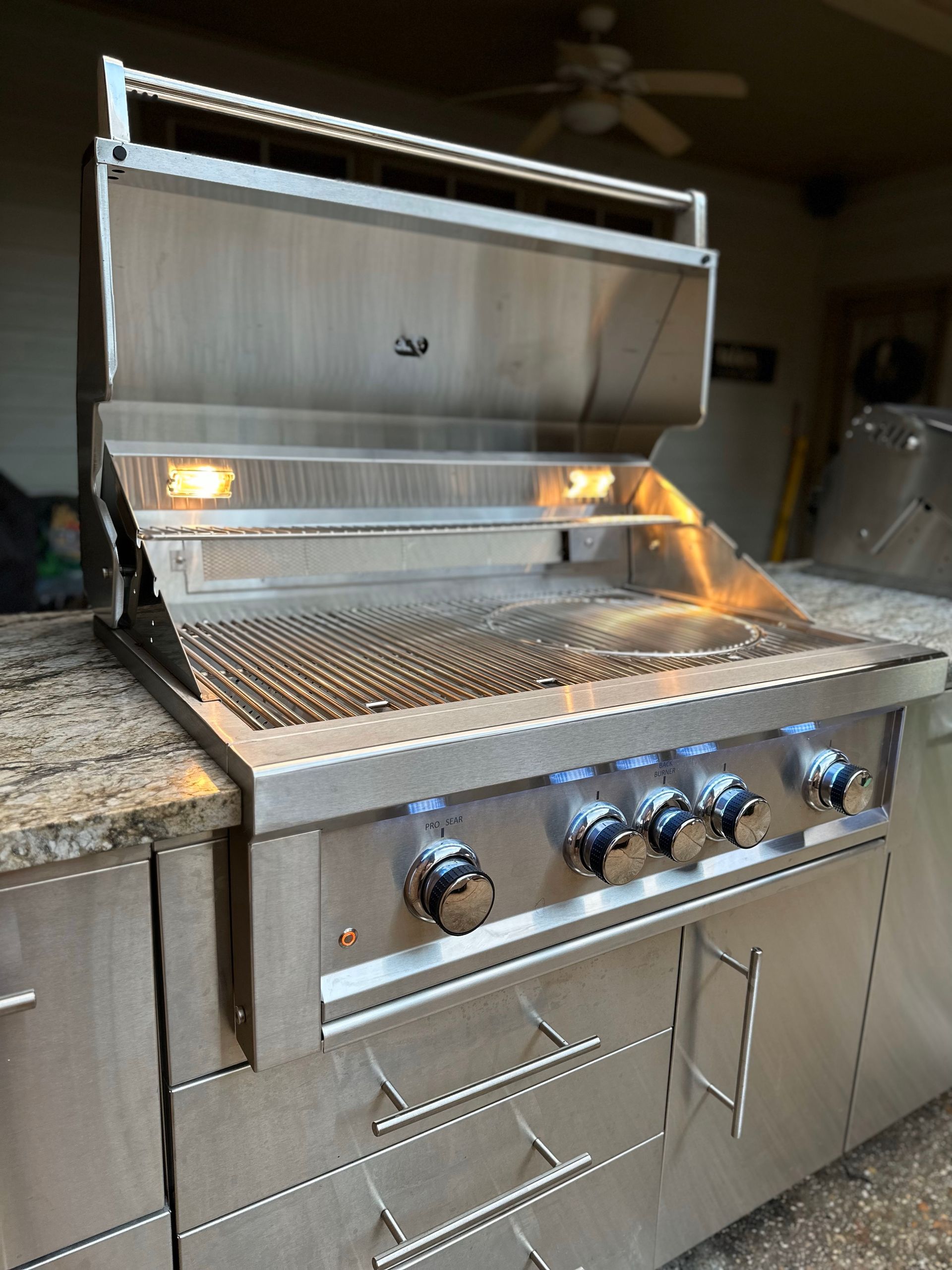 stainless steel bbq with hood open in sunstone outdoor kitchen