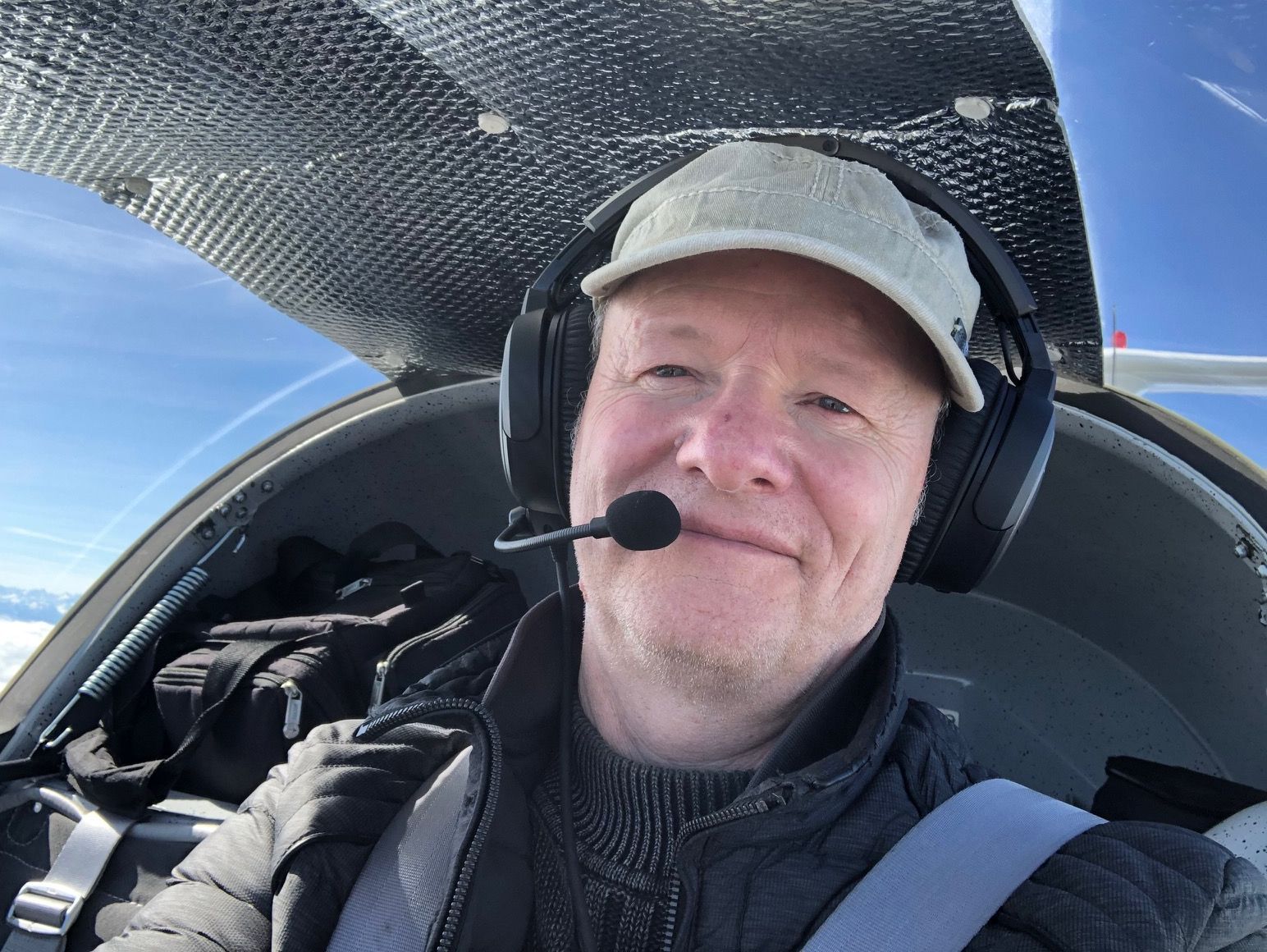 Thomas Brosi in der Dimona D-KBKB Ein Pilot im Cockpit eines Flugzeugs, mit Schildmütze und Headset.