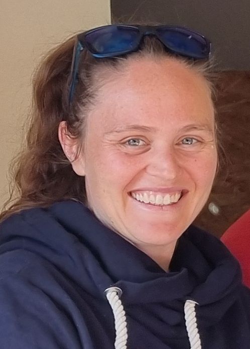 Portrait von Lucia Liehr Portrait einer Frau mit zurückgesteckten Haaren, Sonnenbrille und dunkelblauem Hoodie mit weißen Bändeln.