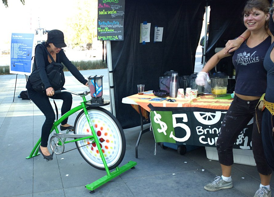 3 personnes sur le stand du vélo à smoothie