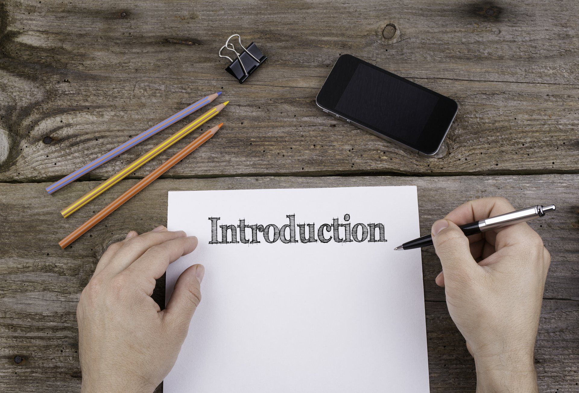 Someone with a notebook and pen writing the introduction to their book