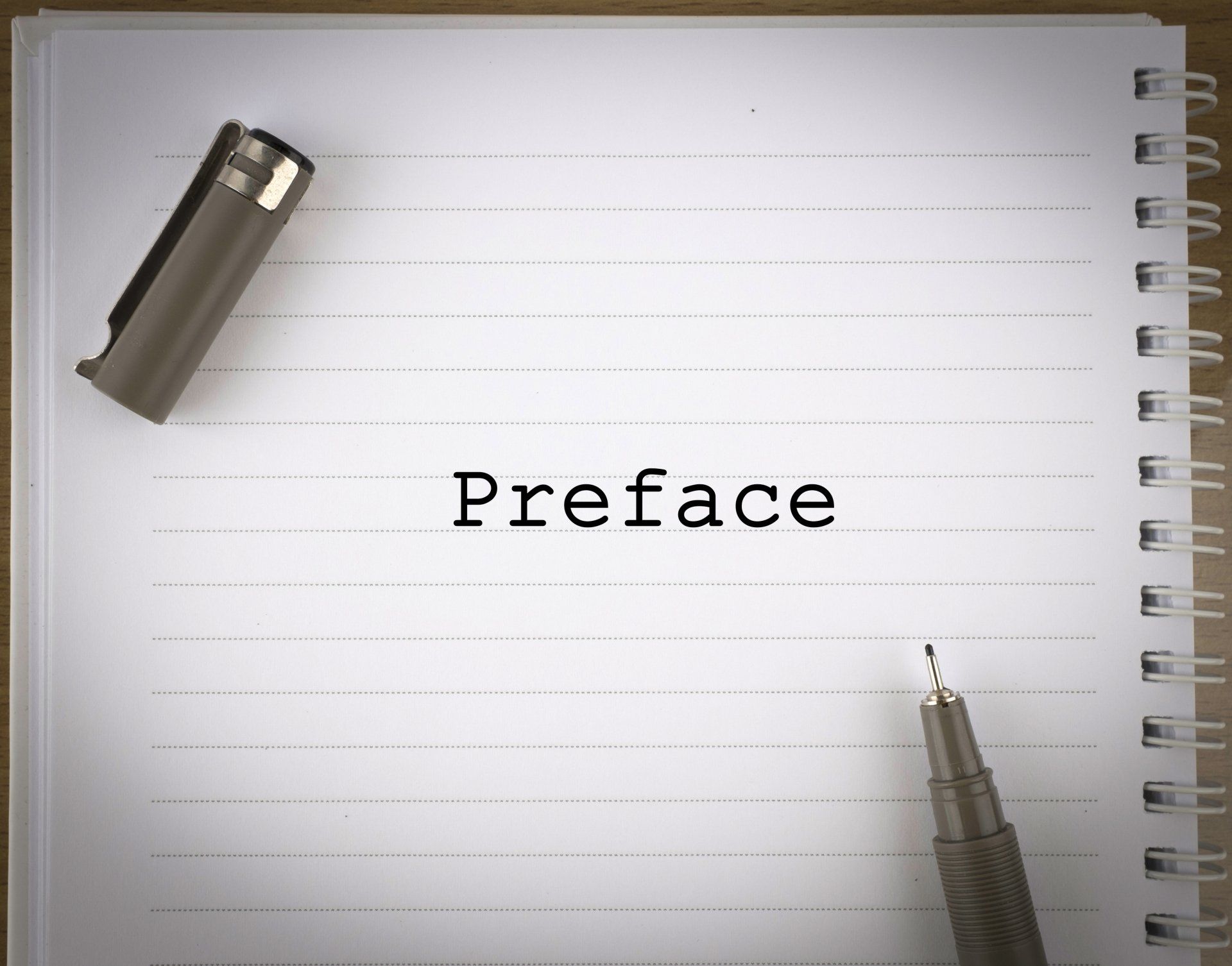 A notepad and pen with the word preface