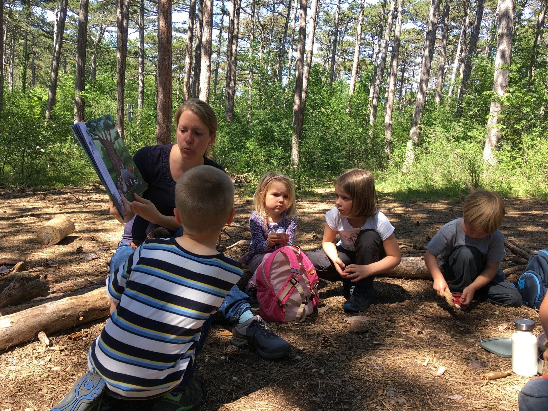 Kinder lauschen einer Geschichte unter einem Baum – Waldgruppe kids bei Natur plus