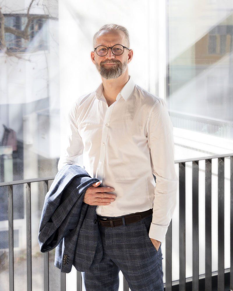 Kommunikationstrainer Andreas Horvath stehend vor Fenster