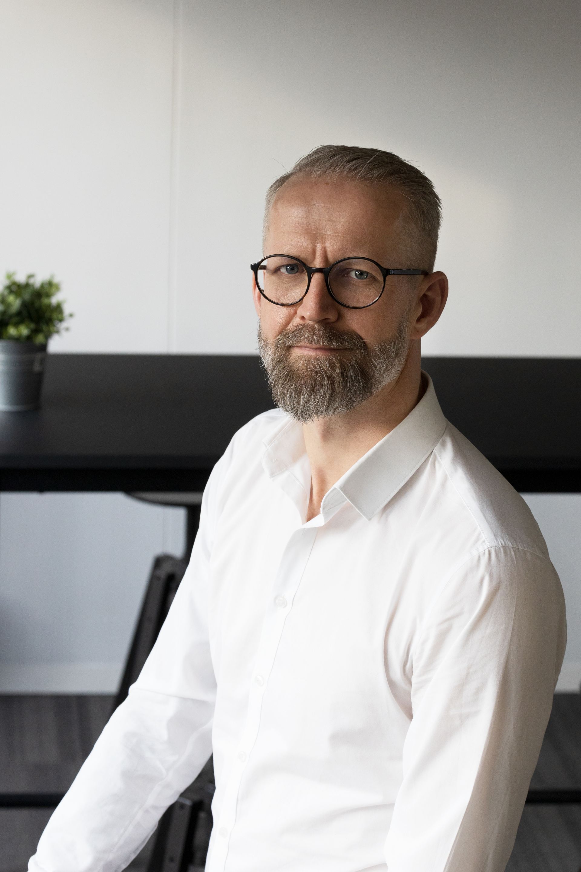 Kommunikationstrainer Andreas Horvath sitzt und hält Stifte