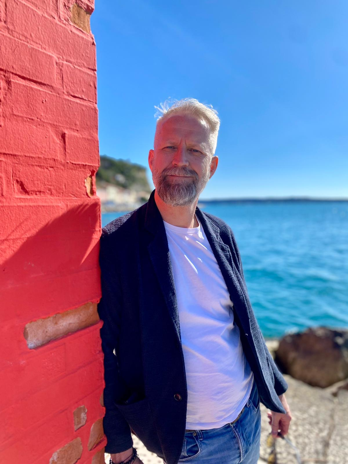 Kommunikationstrainer Andreas Horvath sitzt auf gelber Couch