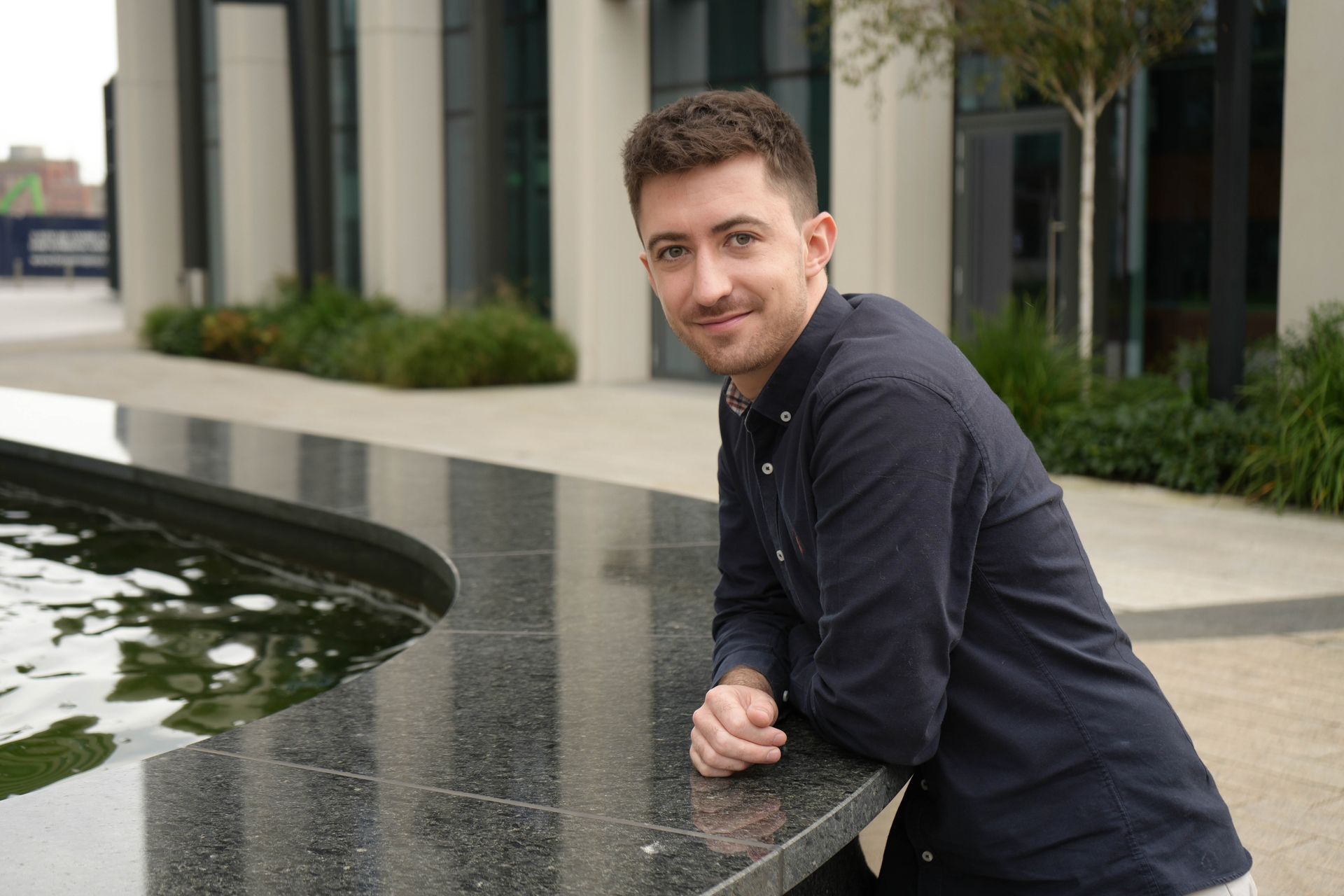 Ciaran Barry standing at a Fountain looking happy