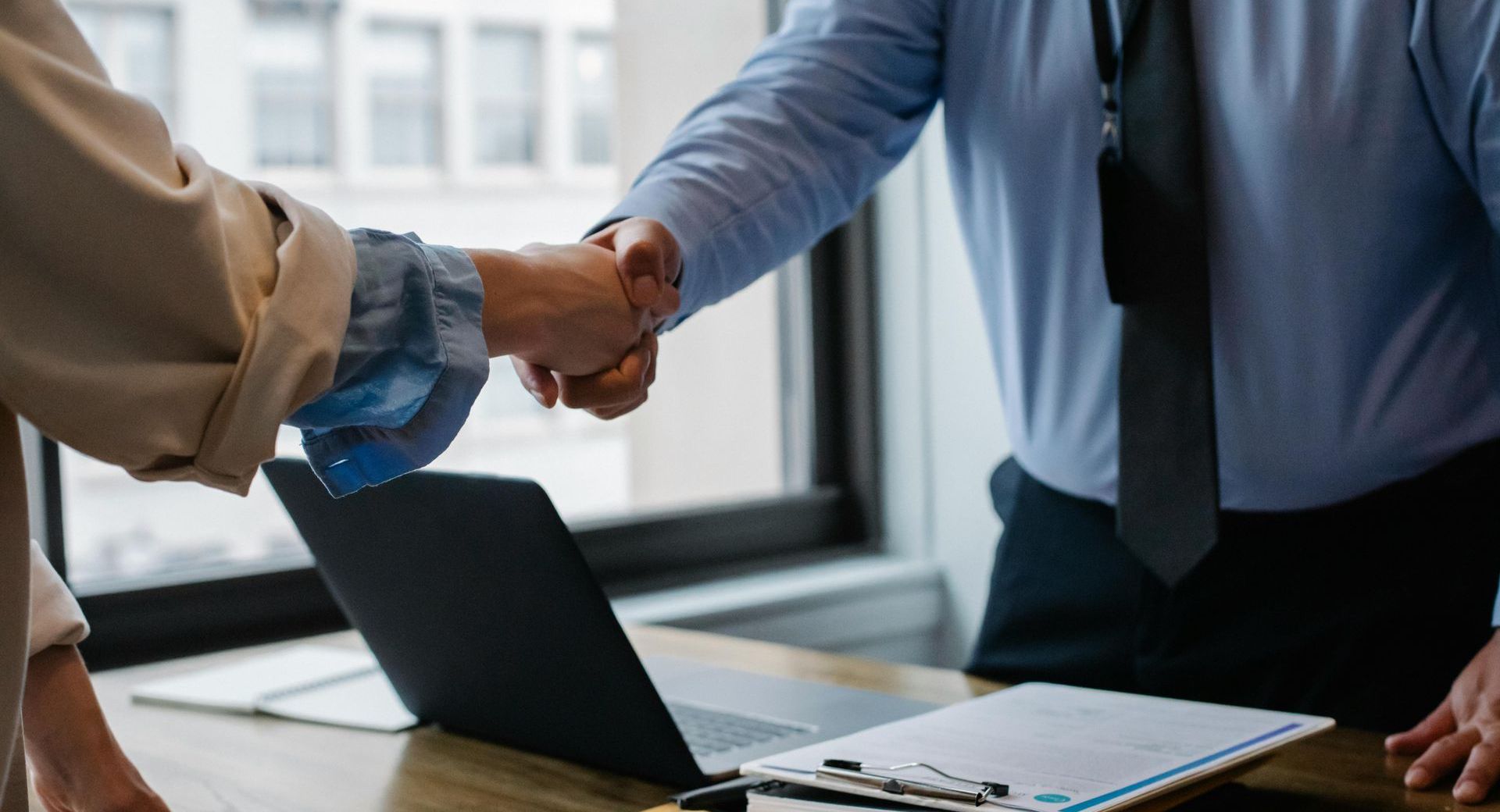 Two people shaking hands in an office