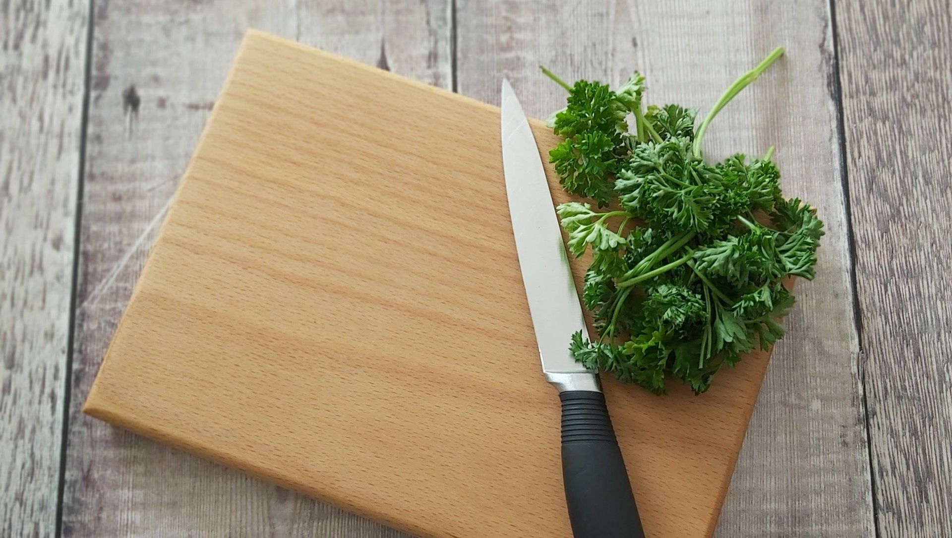 Beech chopping board with knife and parsley