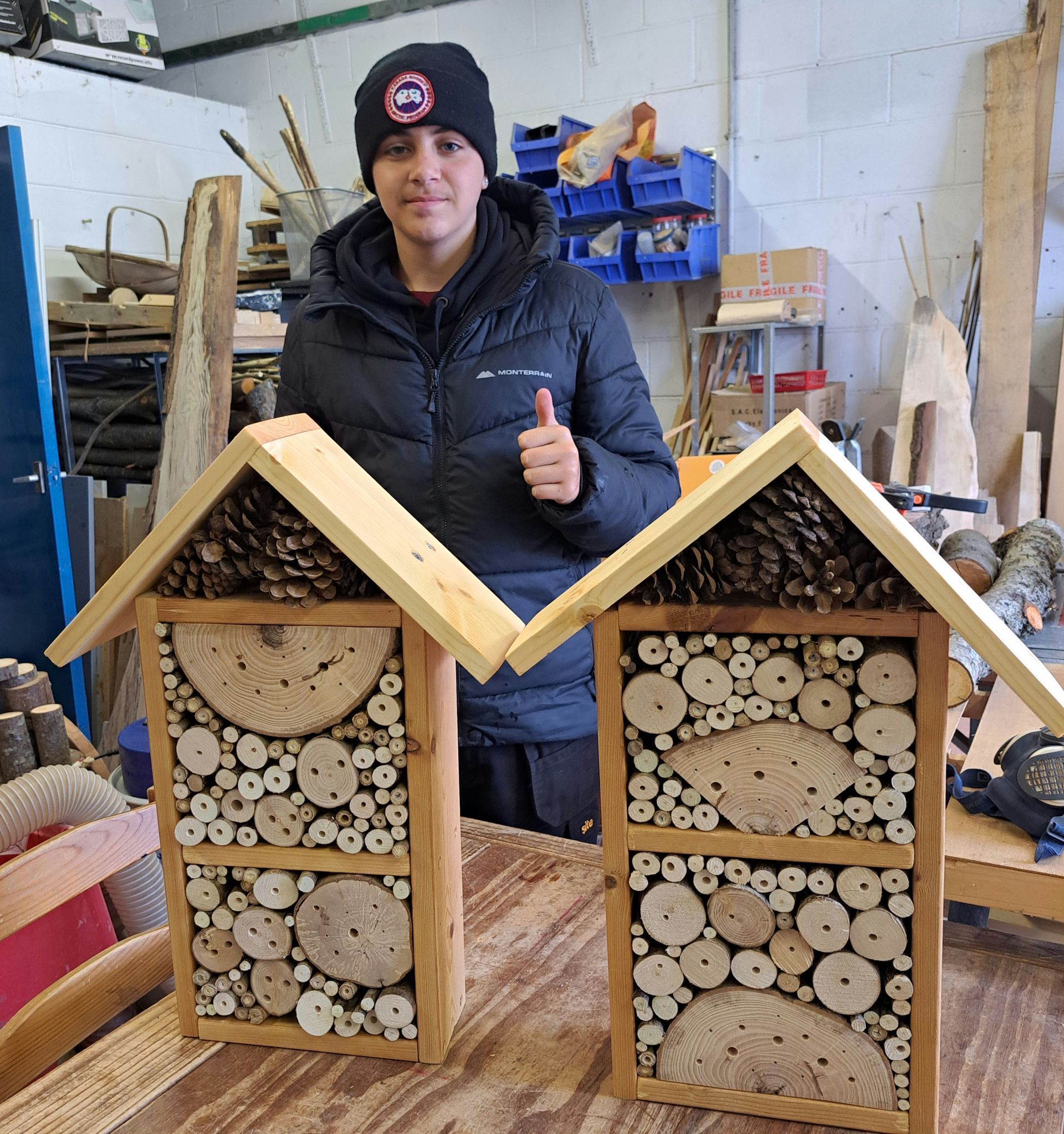 Picture of a smiling work experience student with the work he has created at Cottage Coppicing