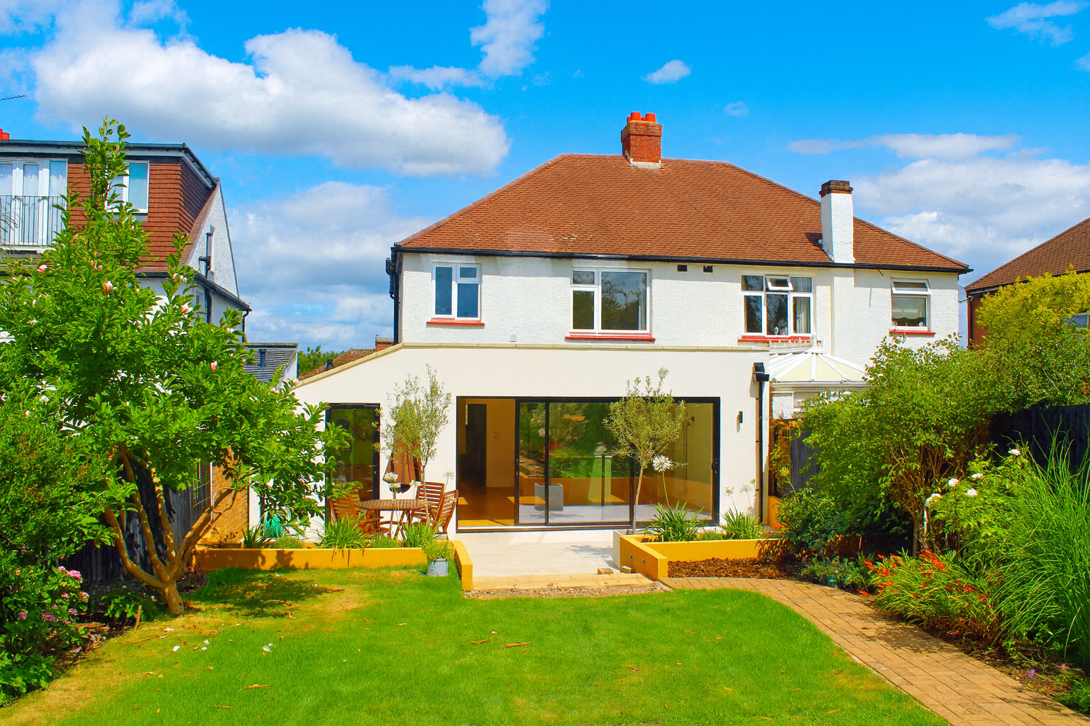 Modern rear extension in KT5, Kingston featuring white render, aluminium bifold doors