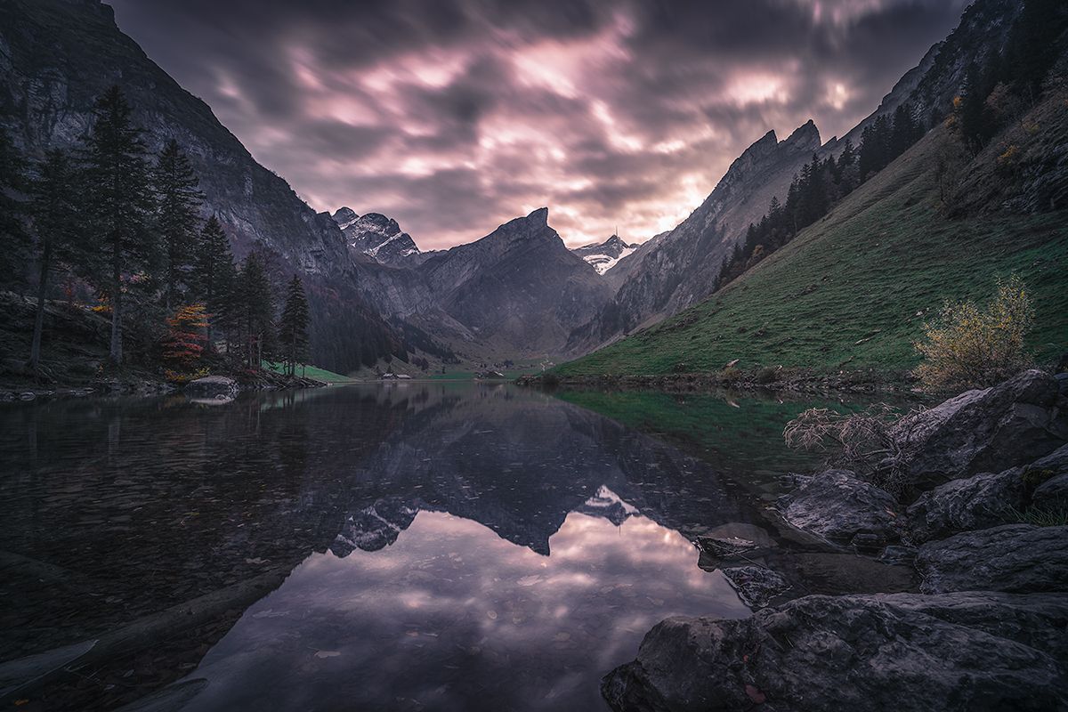 Schweizer Bergsee bei Nacht mit Spiegelung der Bergkulisse im See, Schweiz