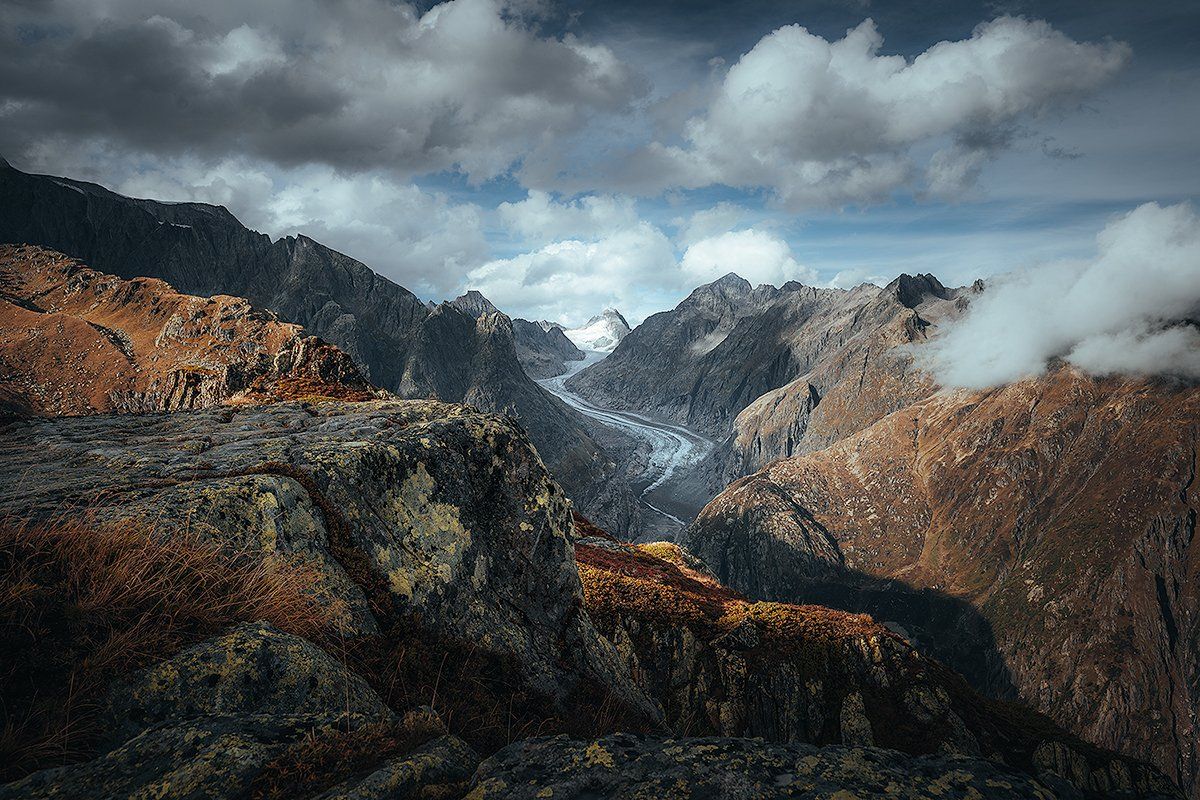 Der Fiescher Gletscher in herbstlichen Farben, umrandet von beeindruckenden Bergen und Anhöhen, Schweiz