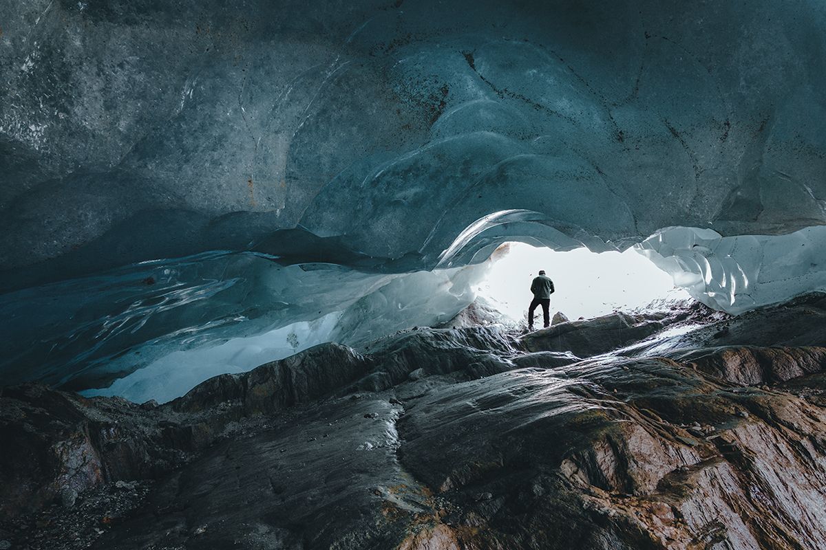 Gletscherhöhle mit beeindruckender Eisdecke und felsigem Boden, Schweiz