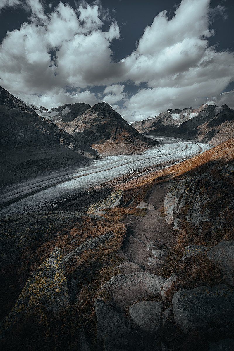 Ein schmaler Pfad am Rande des Aletsch Gletschers mit imposanter Bergkulisse, Schweiz