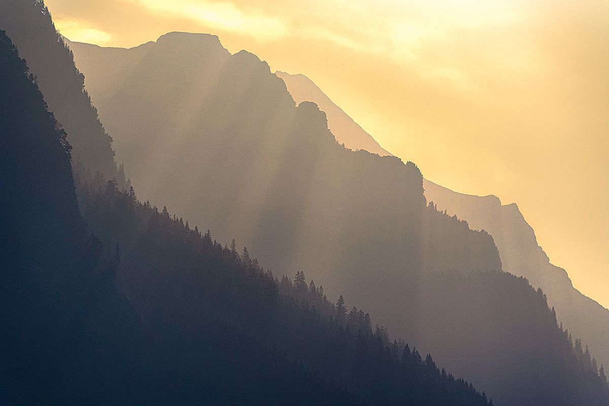 Die untergehende Sonne taucht die Landschaft in ein goldenes Licht und hebt die verschiedenen Ebenen der Berge eindrucksvoll hervor, Schweiz